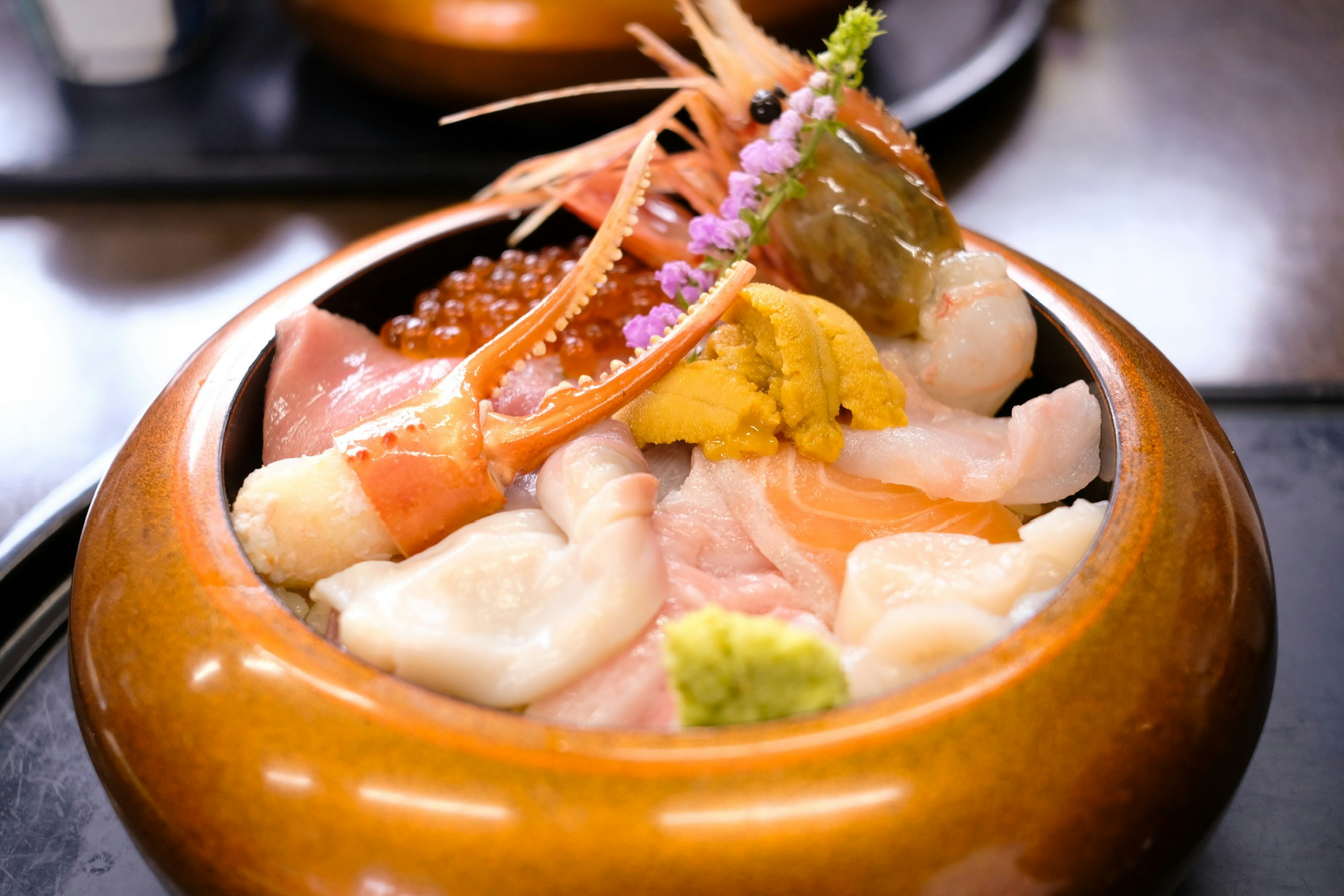 海鮮丼の器に盛られた刺身といくら、わさび添え