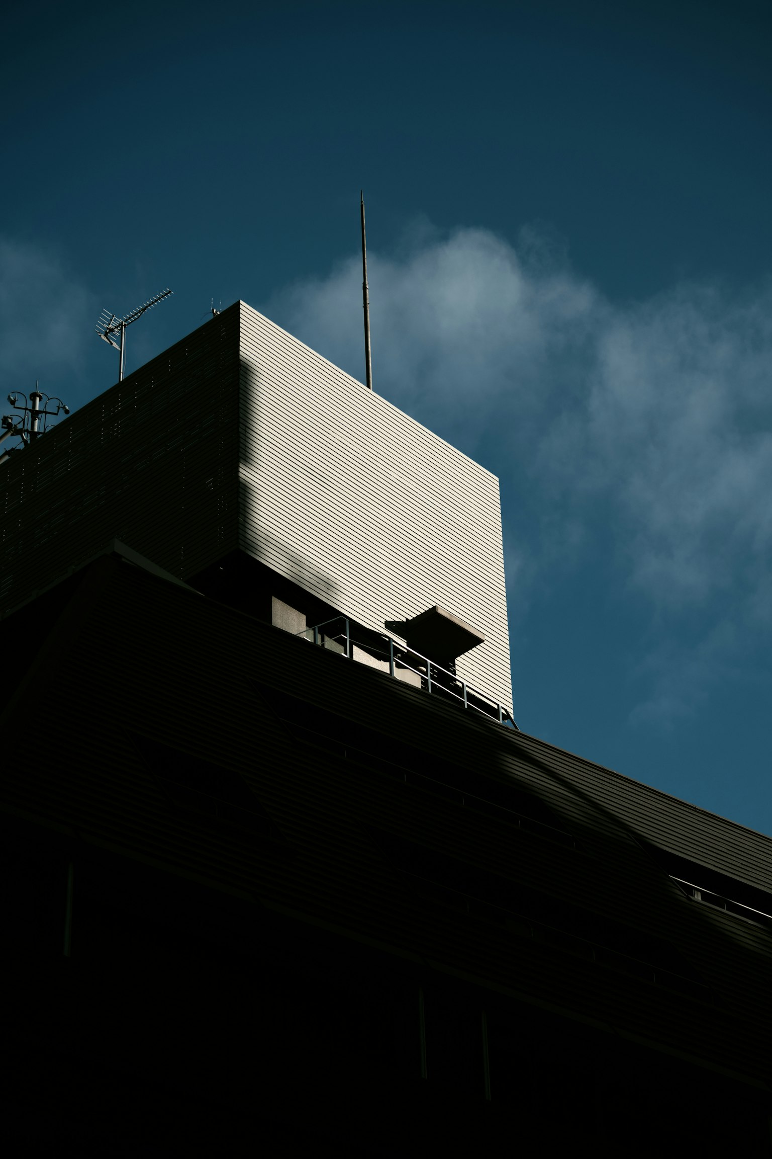 Kontrast einer weißen Wand an einem hohen Gebäude vor einem blauen Himmel