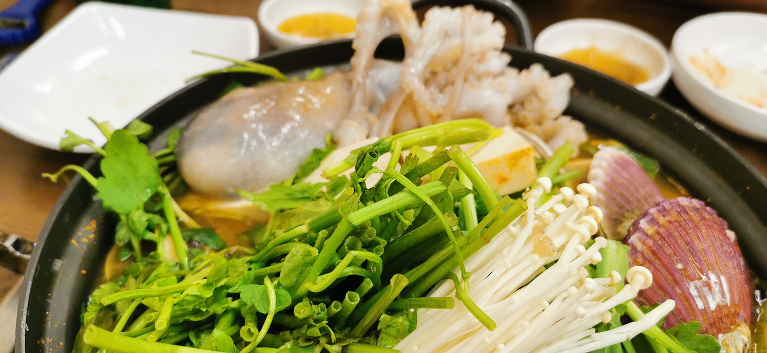Nồi lẩu đầy rau tươi và hải sản