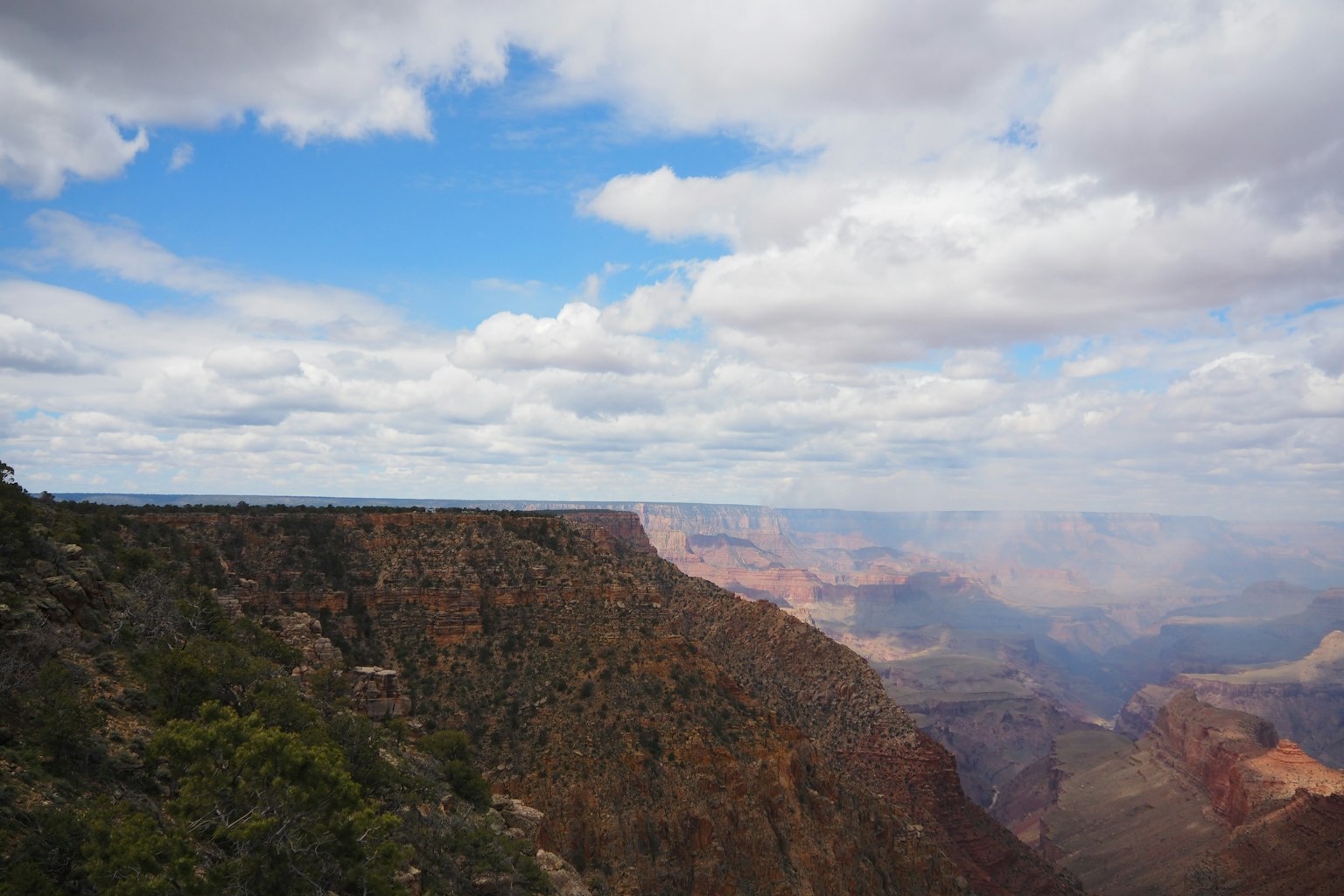 Cảnh quan rộng lớn của Grand Canyon với bầu trời xanh và mây rải rác