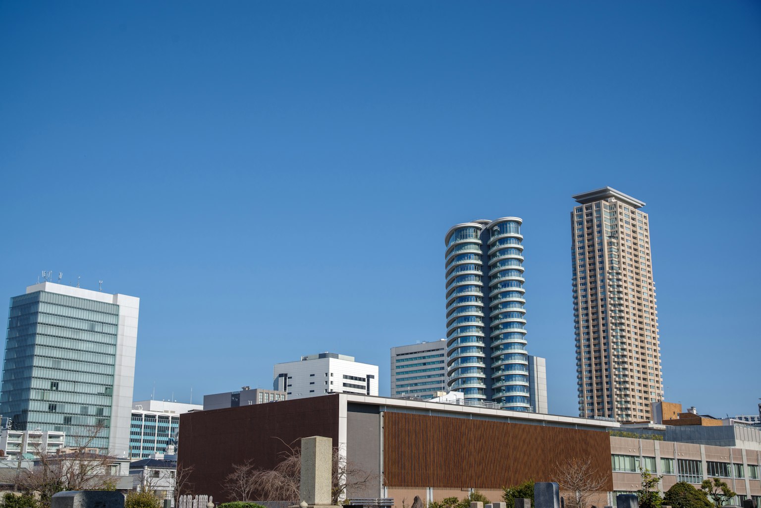 เส้นขอบฟ้าของเมืองที่มีตึกระฟ้าสมัยใหม่ใต้ท้องฟ้าสีฟ้าใส