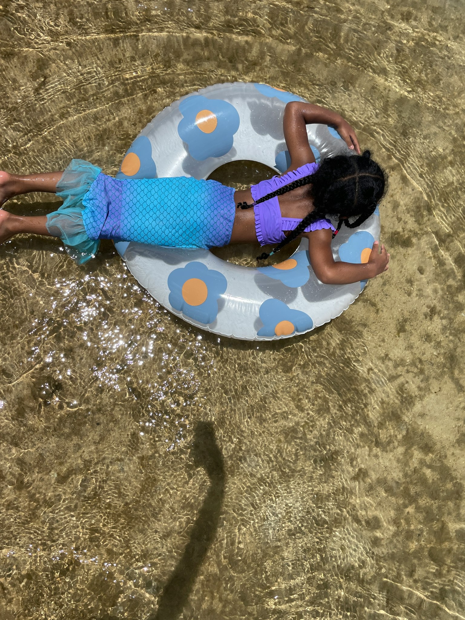 孩子在水中漂浮在彩色浮圈上