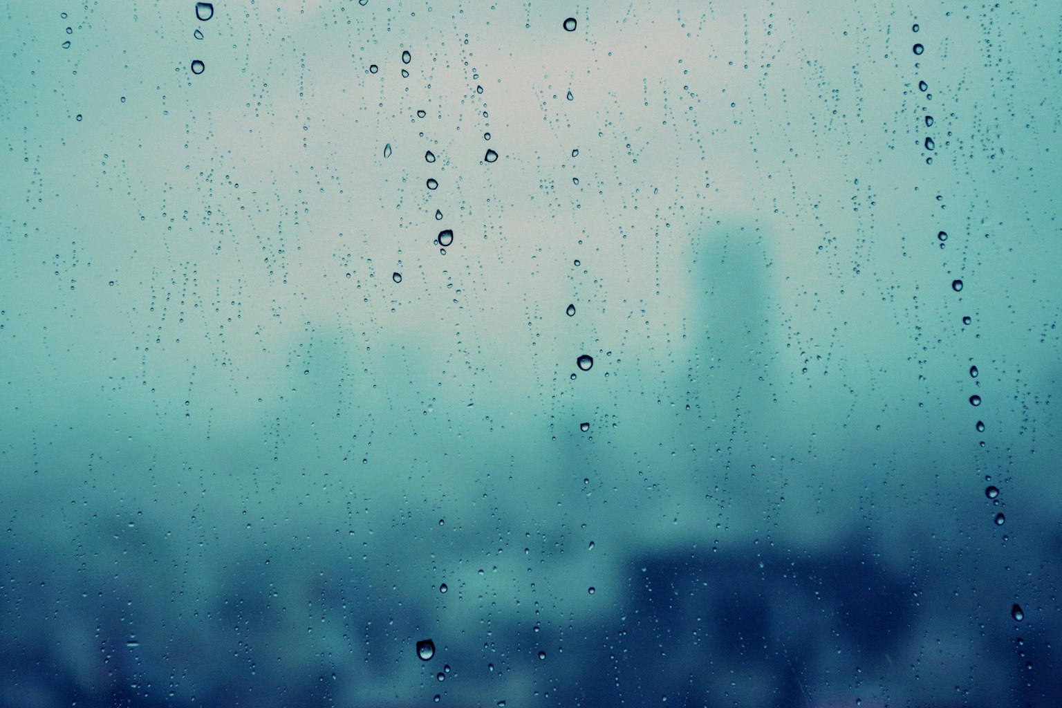 Blurred cityscape viewed through rain droplets on a window