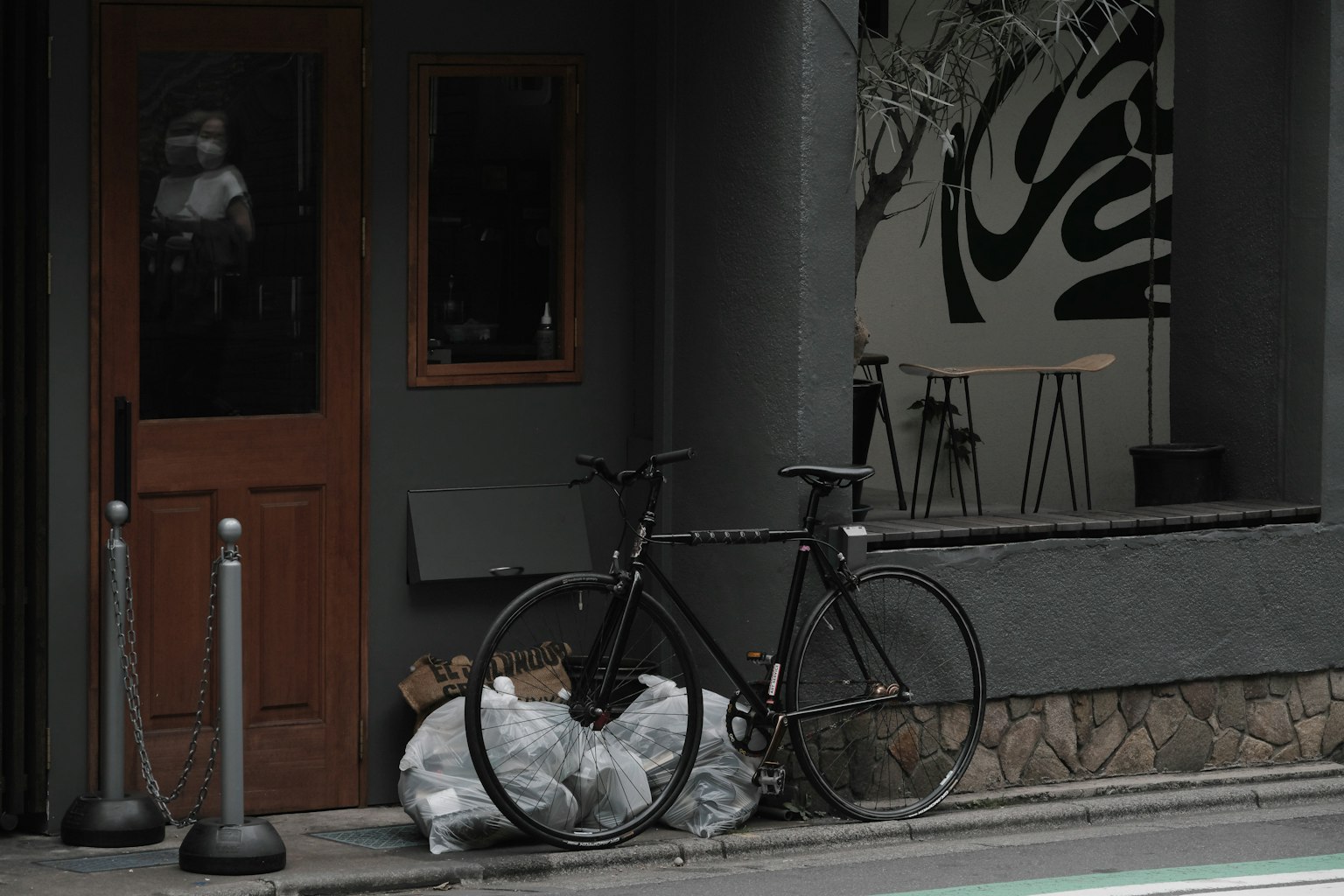Una bicicletta nera parcheggiata accanto a sacchi della spazzatura all'angolo di una strada