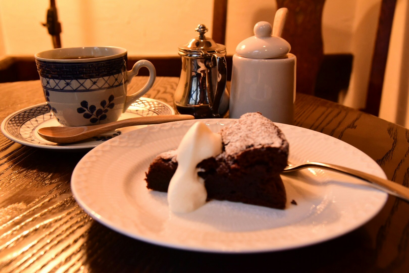 ถ้วยกาแฟและเค้กบนโต๊ะอาหาร