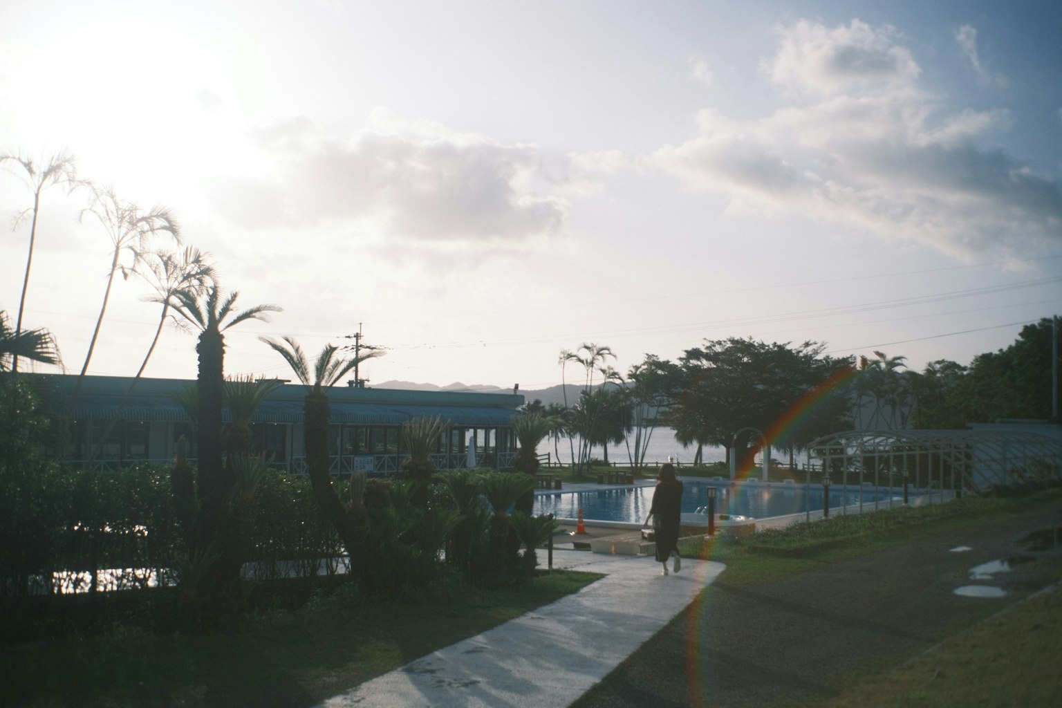 Paysage verdoyant près d'une piscine avec une personne marchant
