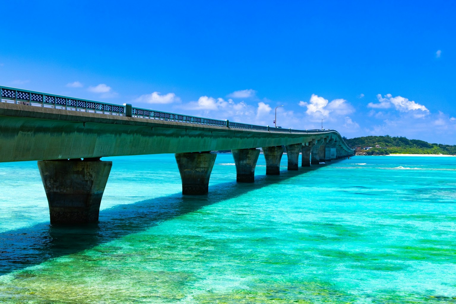 一座跨越碧綠海水的橋，下面可見珊瑚礁