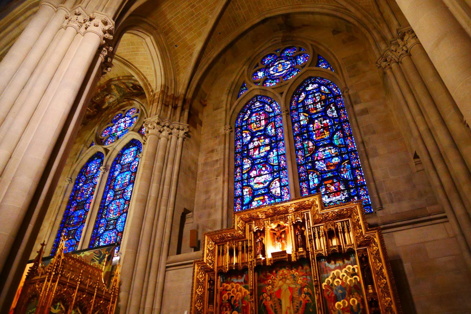 Interior de una iglesia con hermosas vidrieras y un altar ornamentado