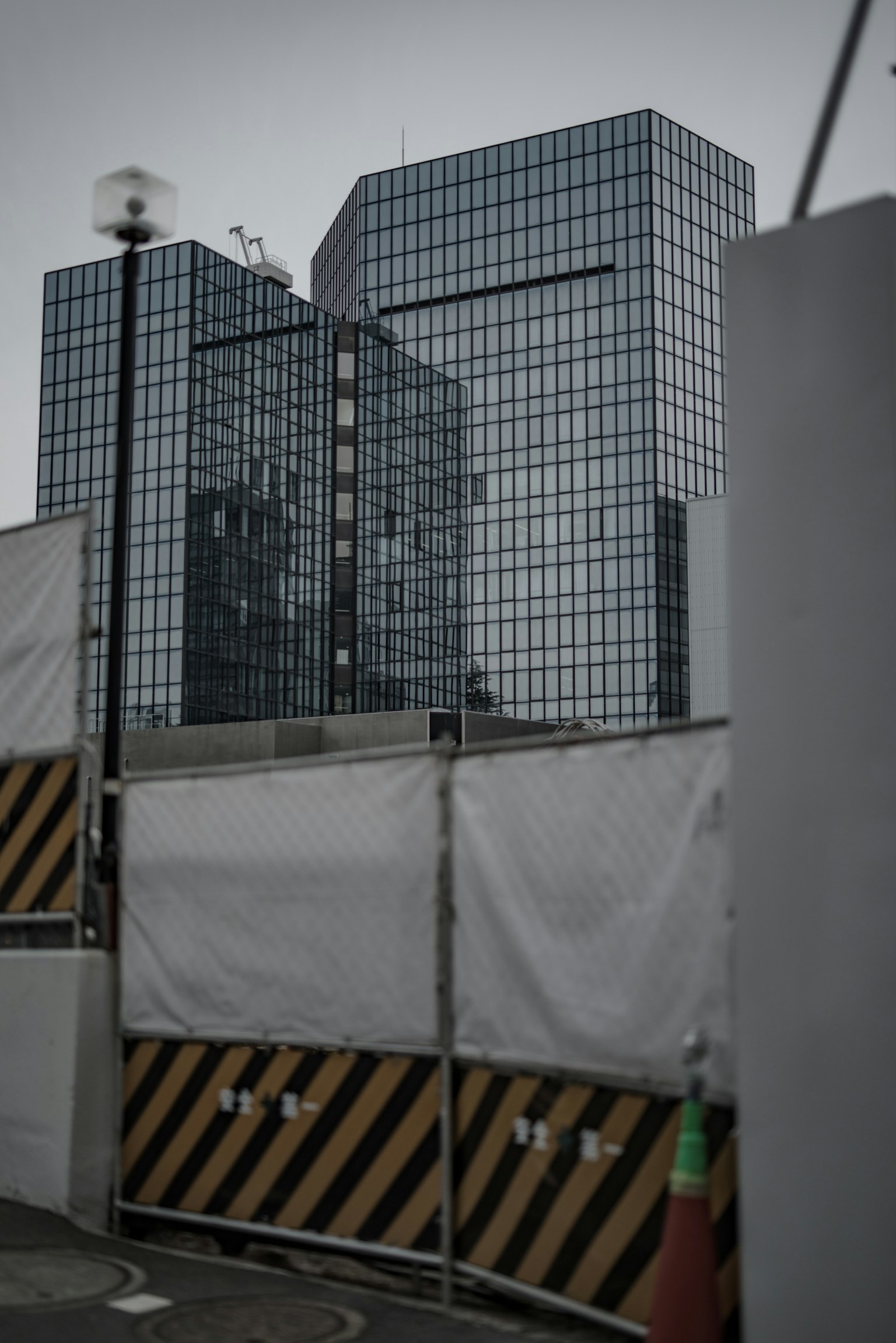 建築工地圍籬後面可見的玻璃建築