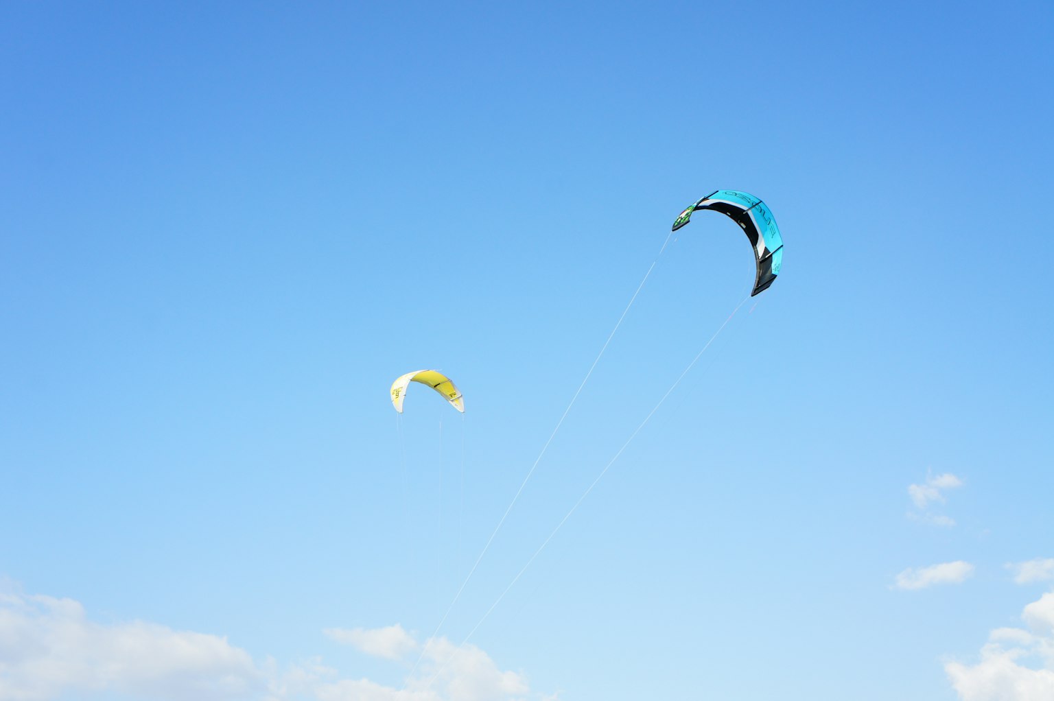 Kites in blue sky with yellow and turquoise colors