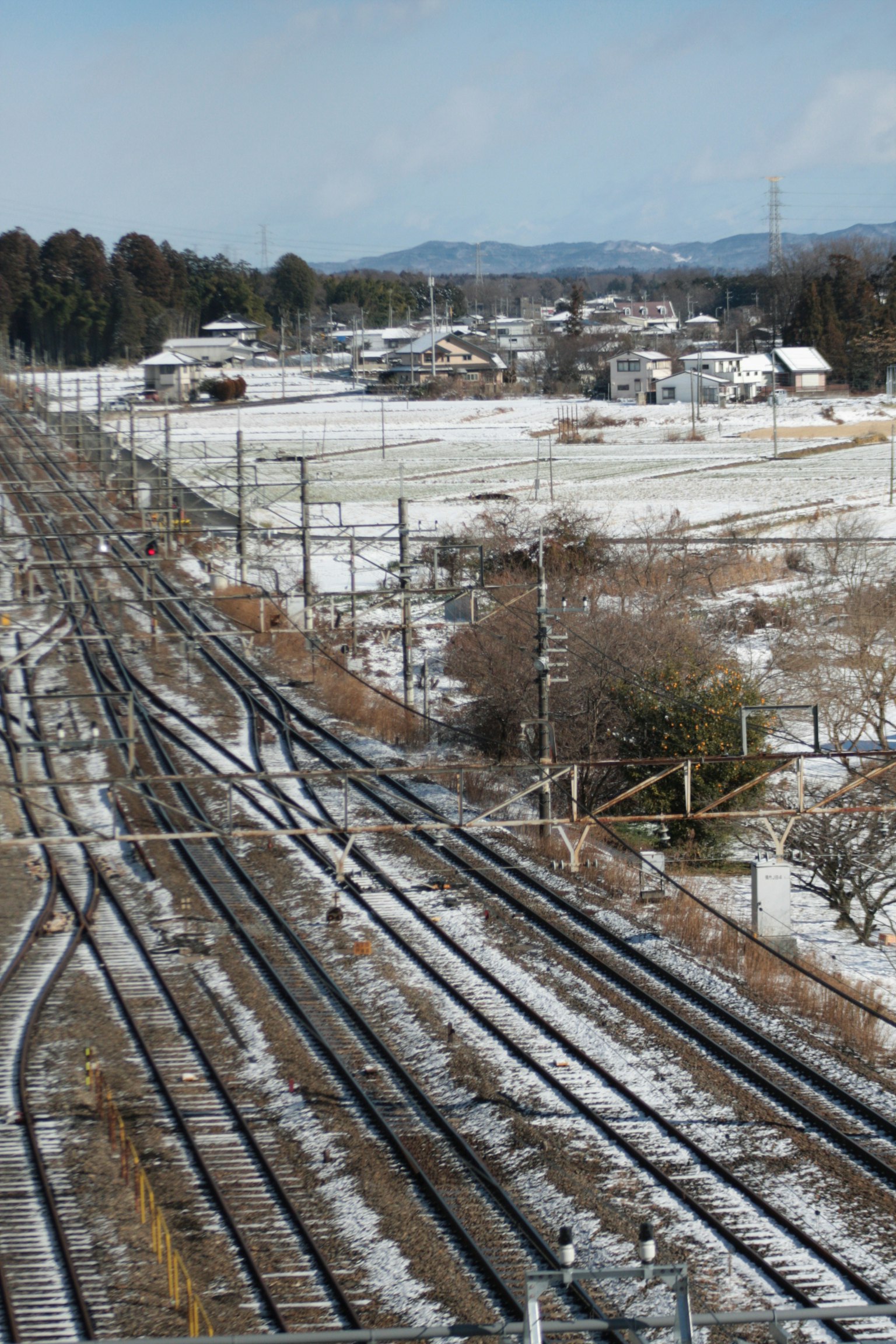Paisaje ferroviario cubierto de nieve con casas circundantes