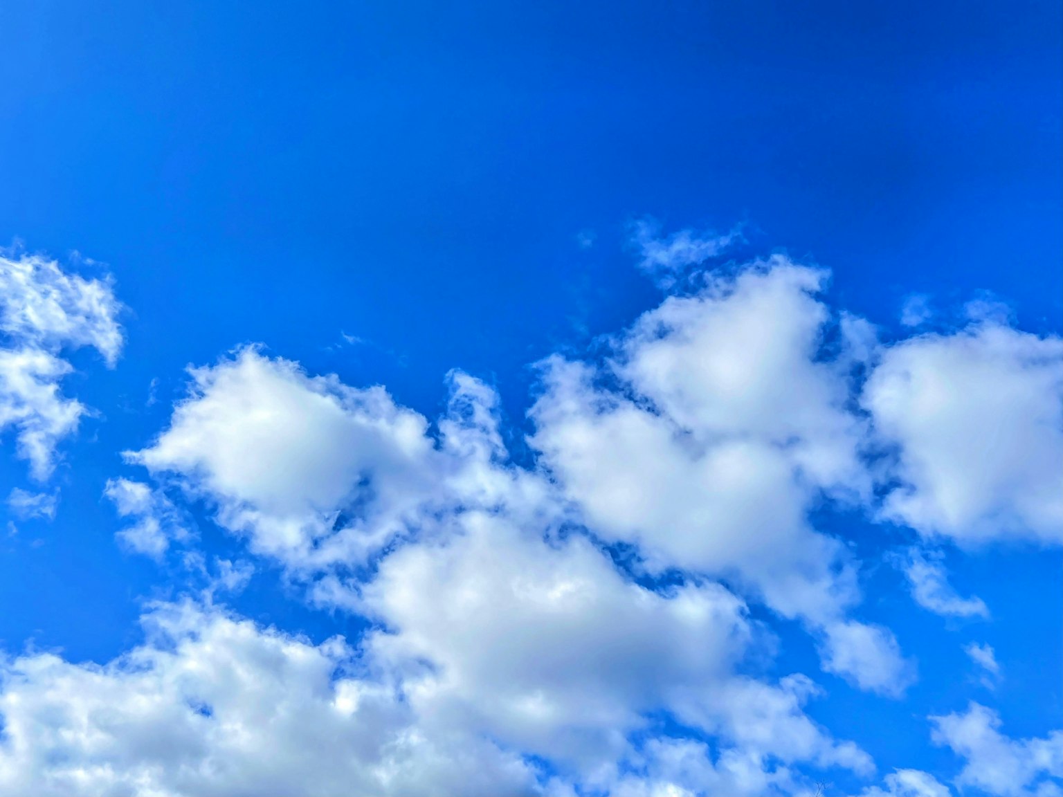 Un paysage avec des nuages blancs flottant dans un ciel bleu