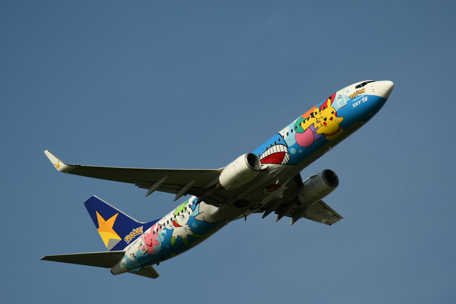 Bunt bemaltes Flugzeug mit verspieltem Design fliegt im blauen Himmel