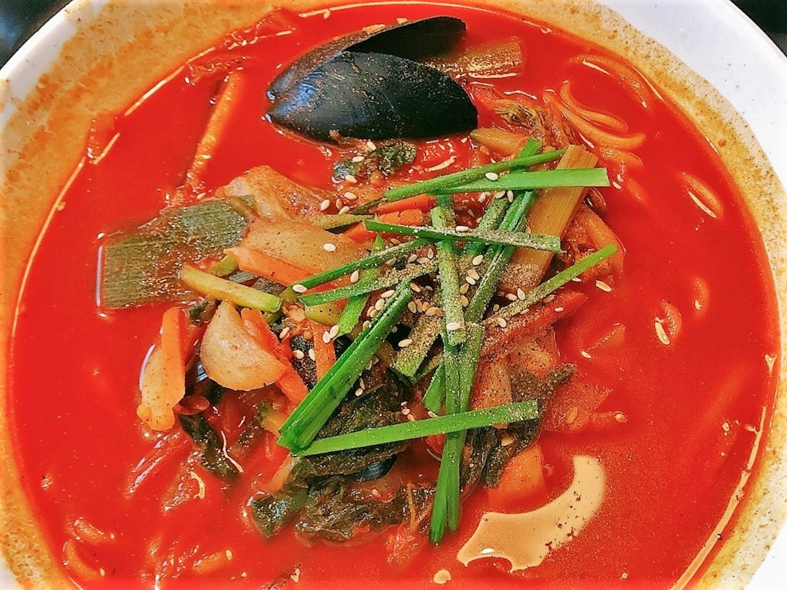 Une soupe rouge vibrante remplie de légumes et de fruits de mer