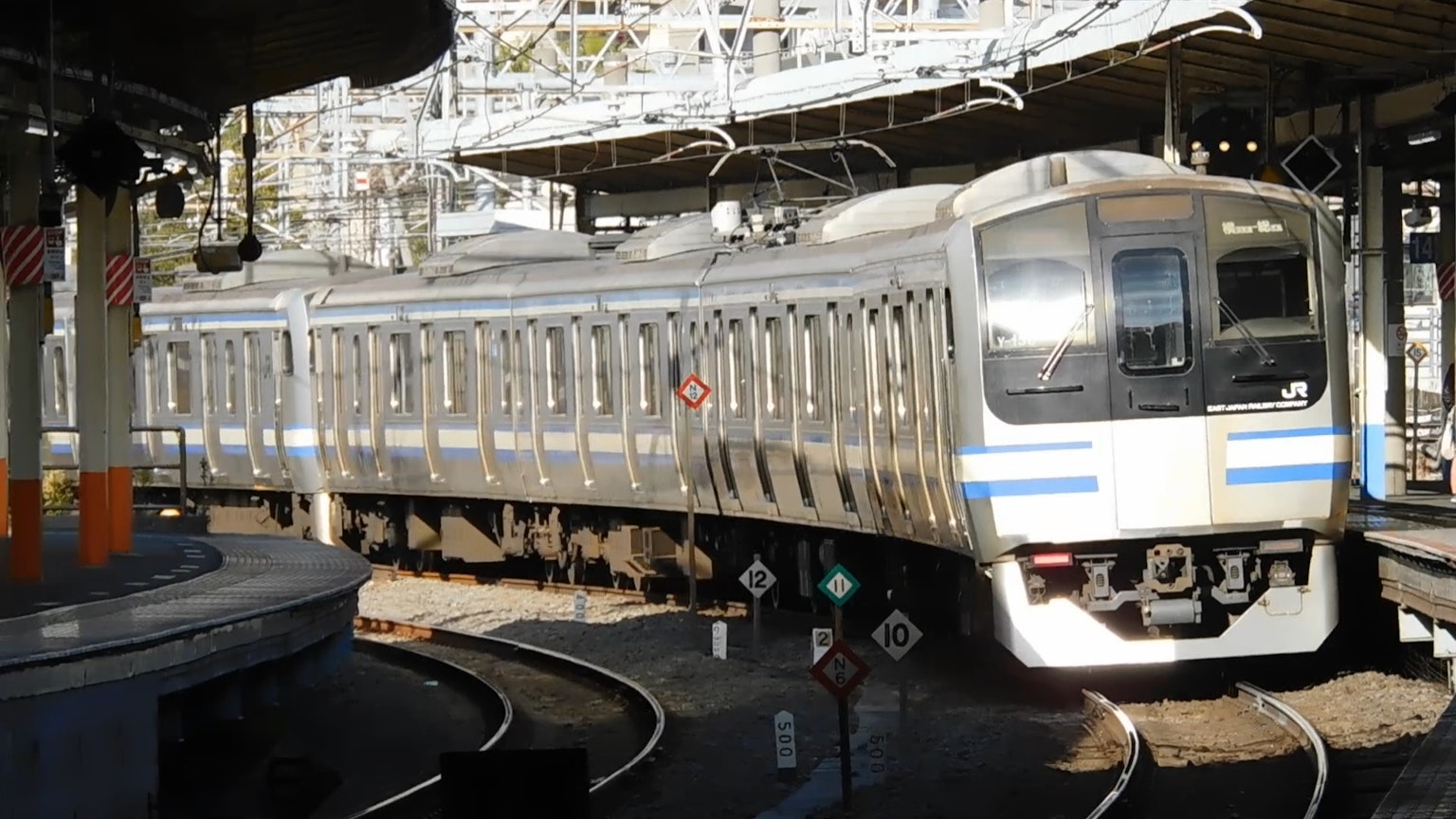 Treno argento che percorre un binario curvo