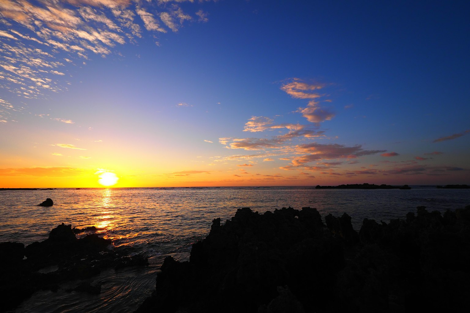 美麗的日落在海面上藍天和散落的雲層