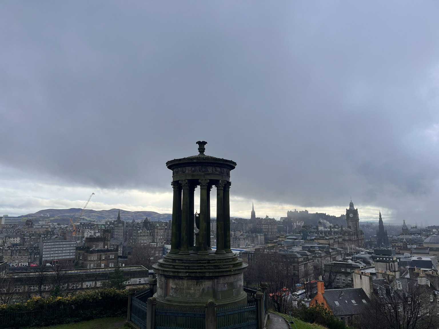 Monumen yang mengawasi cakrawala Edinburgh di bawah langit mendung
