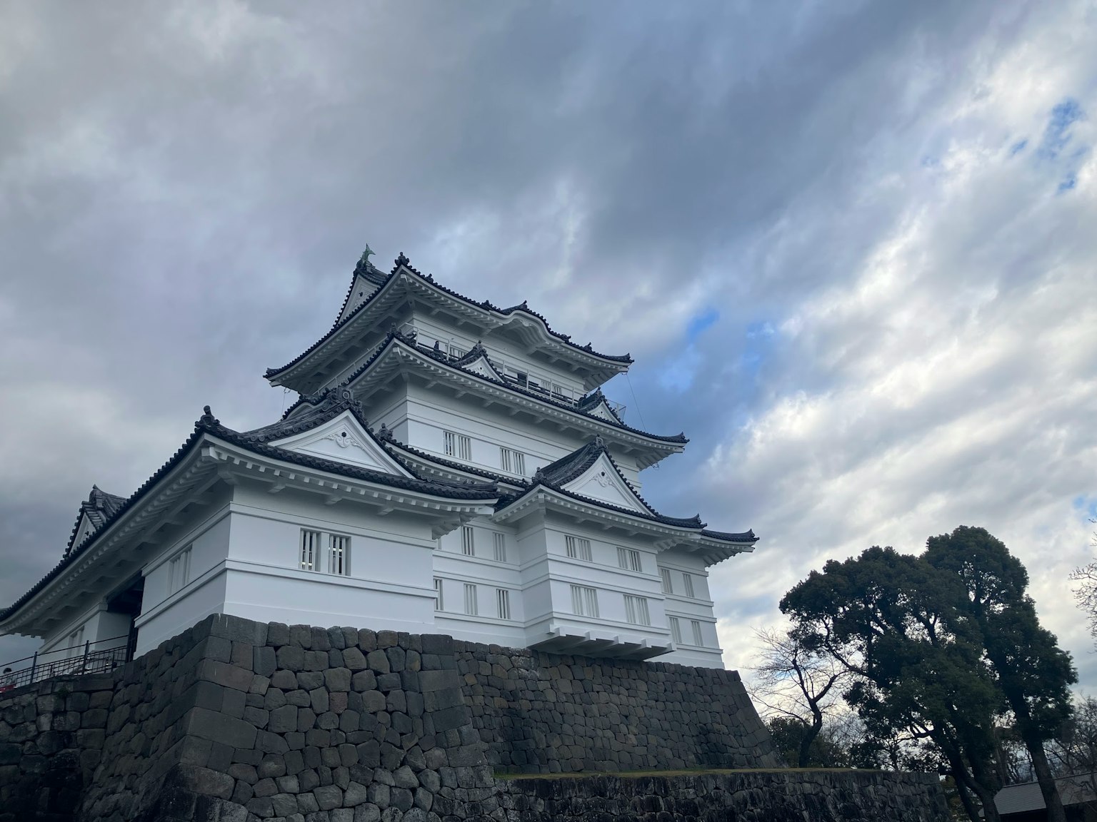 Un castello bianco si erge su una base di pietra sotto un cielo nuvoloso