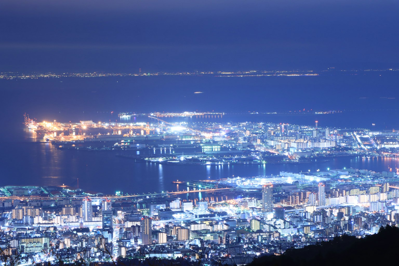 Vista nocturna de una ciudad con luces brillantes y un puerto