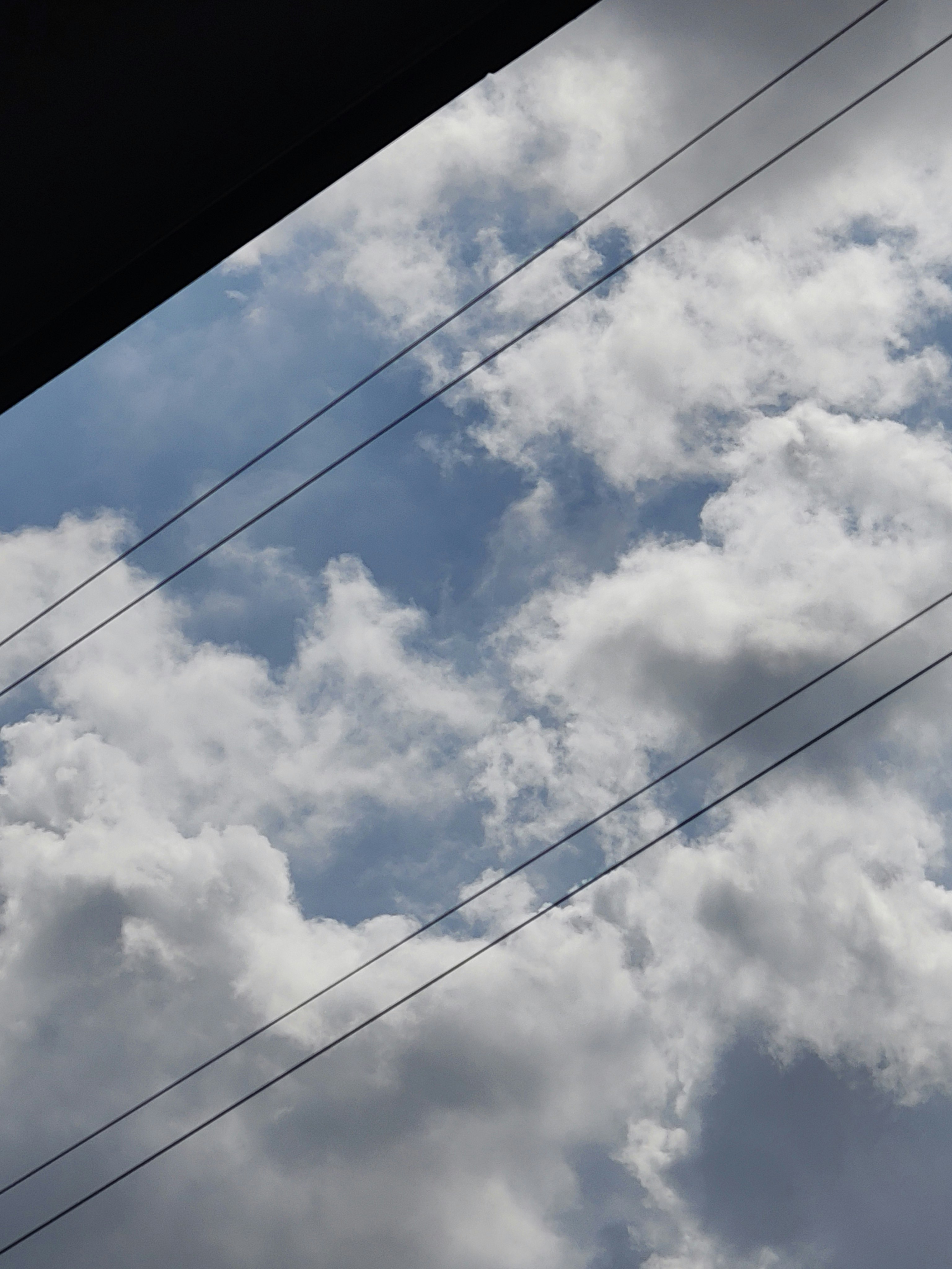 雲の広がる青空と電線の交差する空の風景