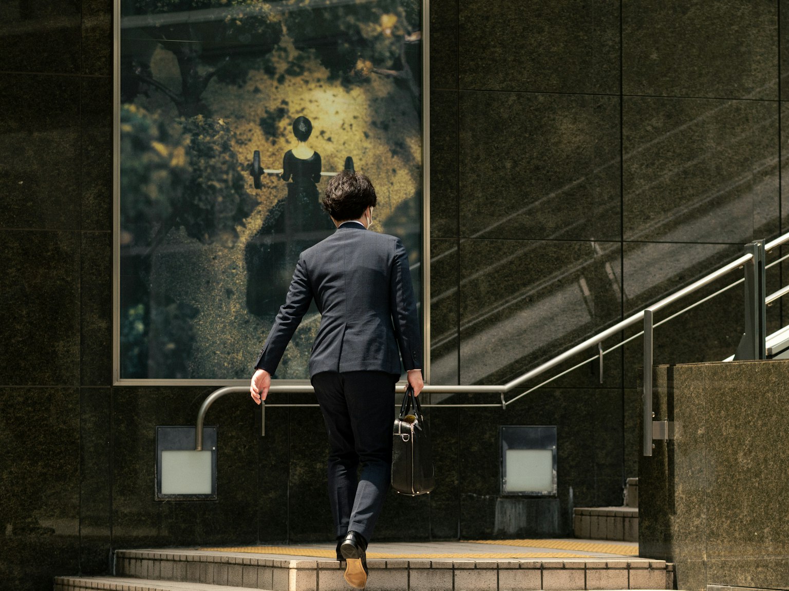 Homme d'affaires montant des escaliers avec une œuvre d'art en arrière-plan