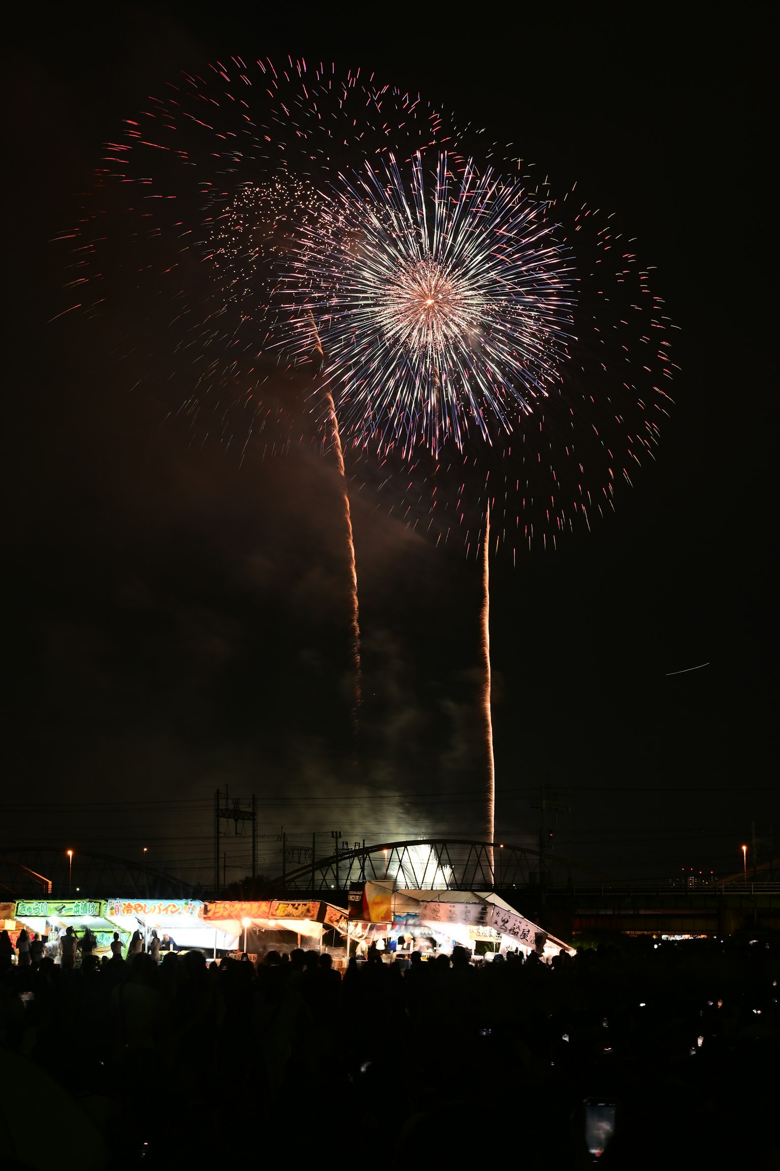 Feuerwerk im Nachthimmel mit Menschenmenge darunter