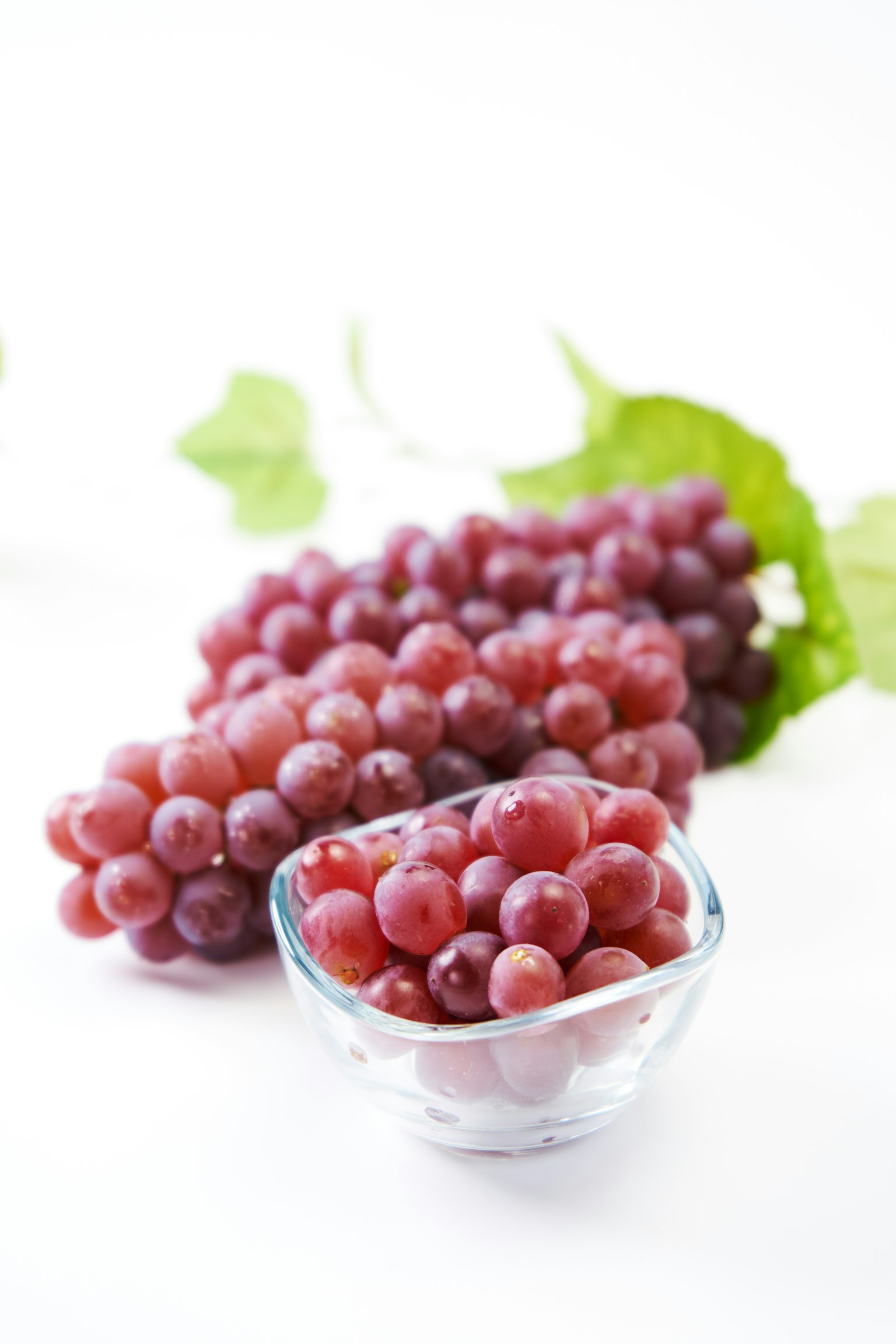 Frische rote Trauben mit einer Schüssel Trauben im Vordergrund