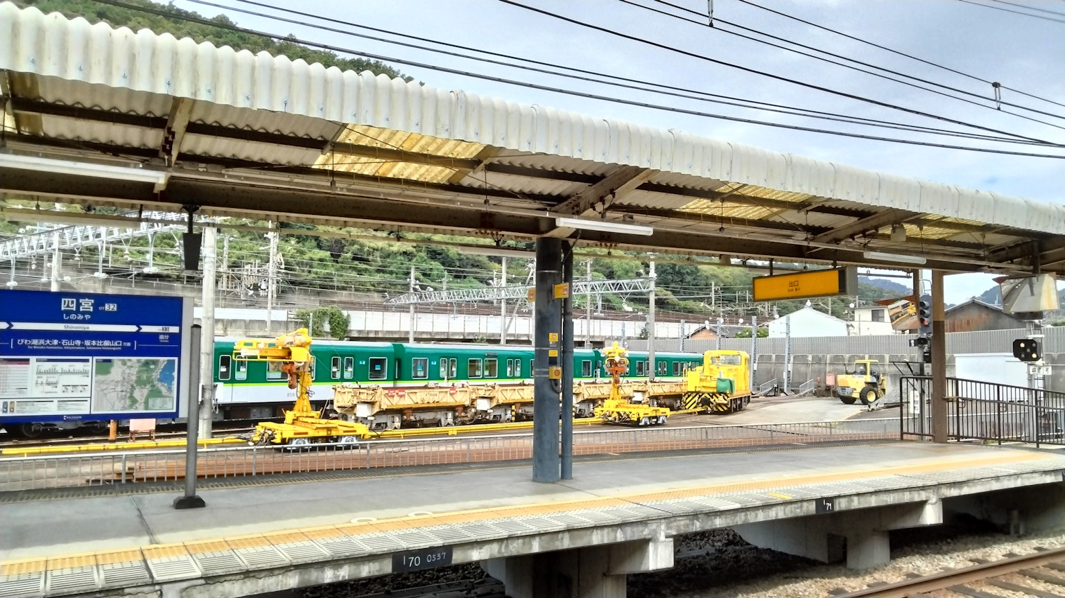 Blick auf einen Zug und Wartungsfahrzeuge von einem Bahnhofsbett