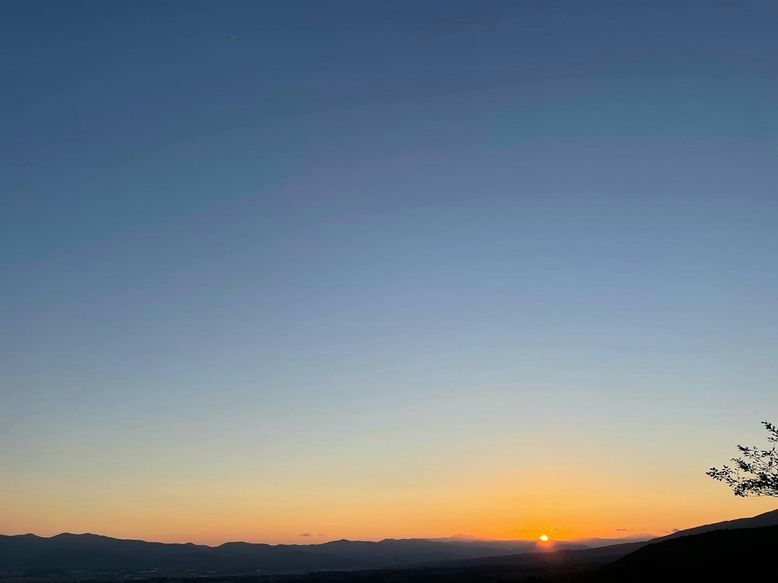 Cielo al atardecer con siluetas de montañas
