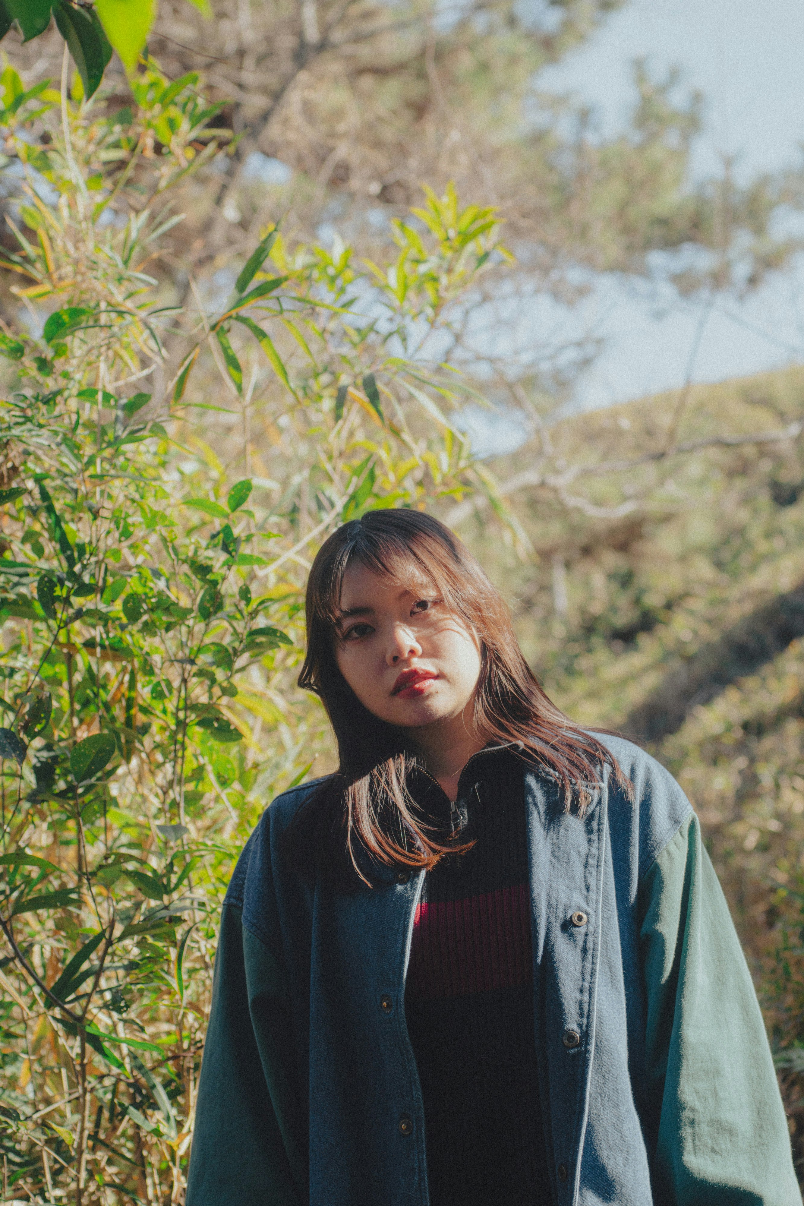 woman standing outdoors among greenery