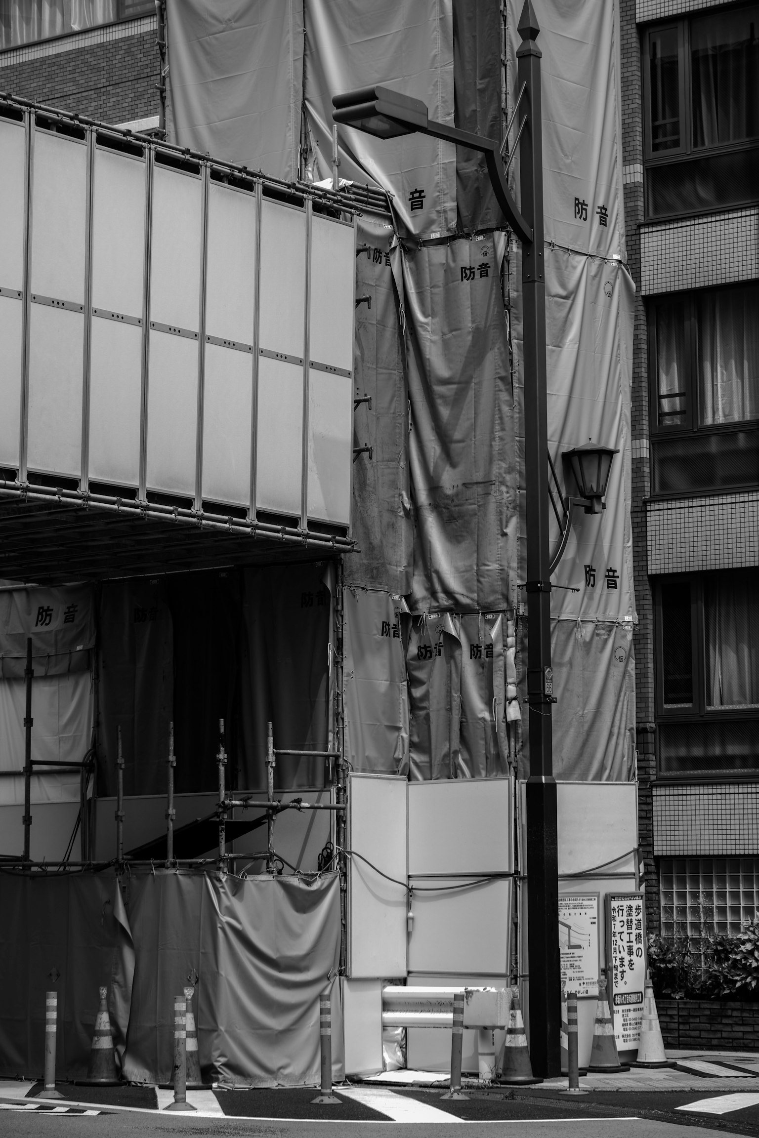 Image en noir et blanc d'un bâtiment en construction avec échafaudage