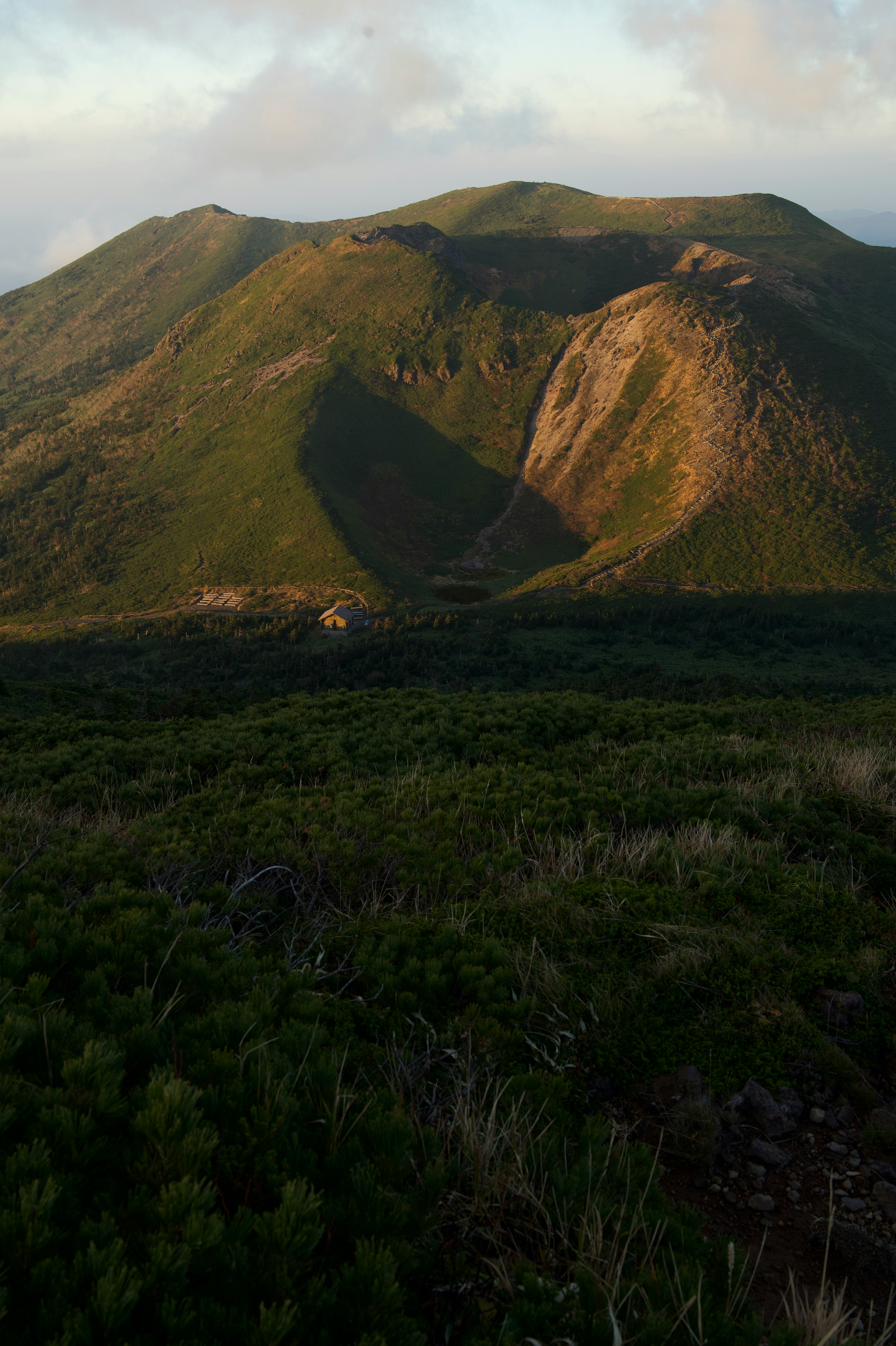 草原の手前に広がる山並みの稜線と谷の風景