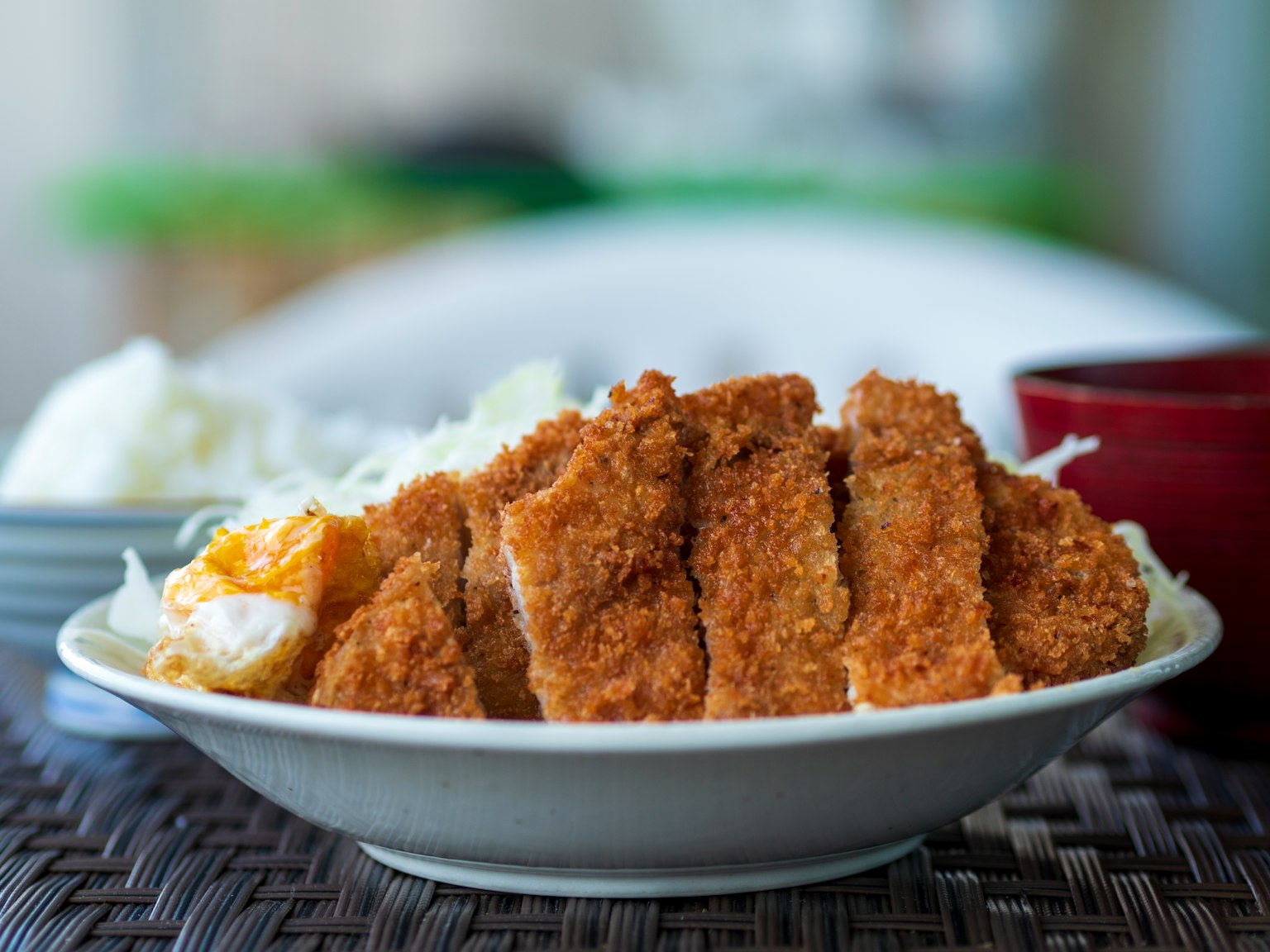 Piatto di cotoletta di maiale impanata servita con riso e cavolo