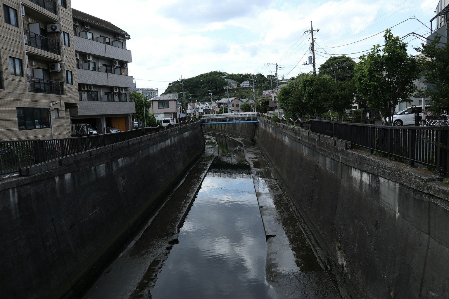 Narrow waterway reflecting surrounding buildings and sky