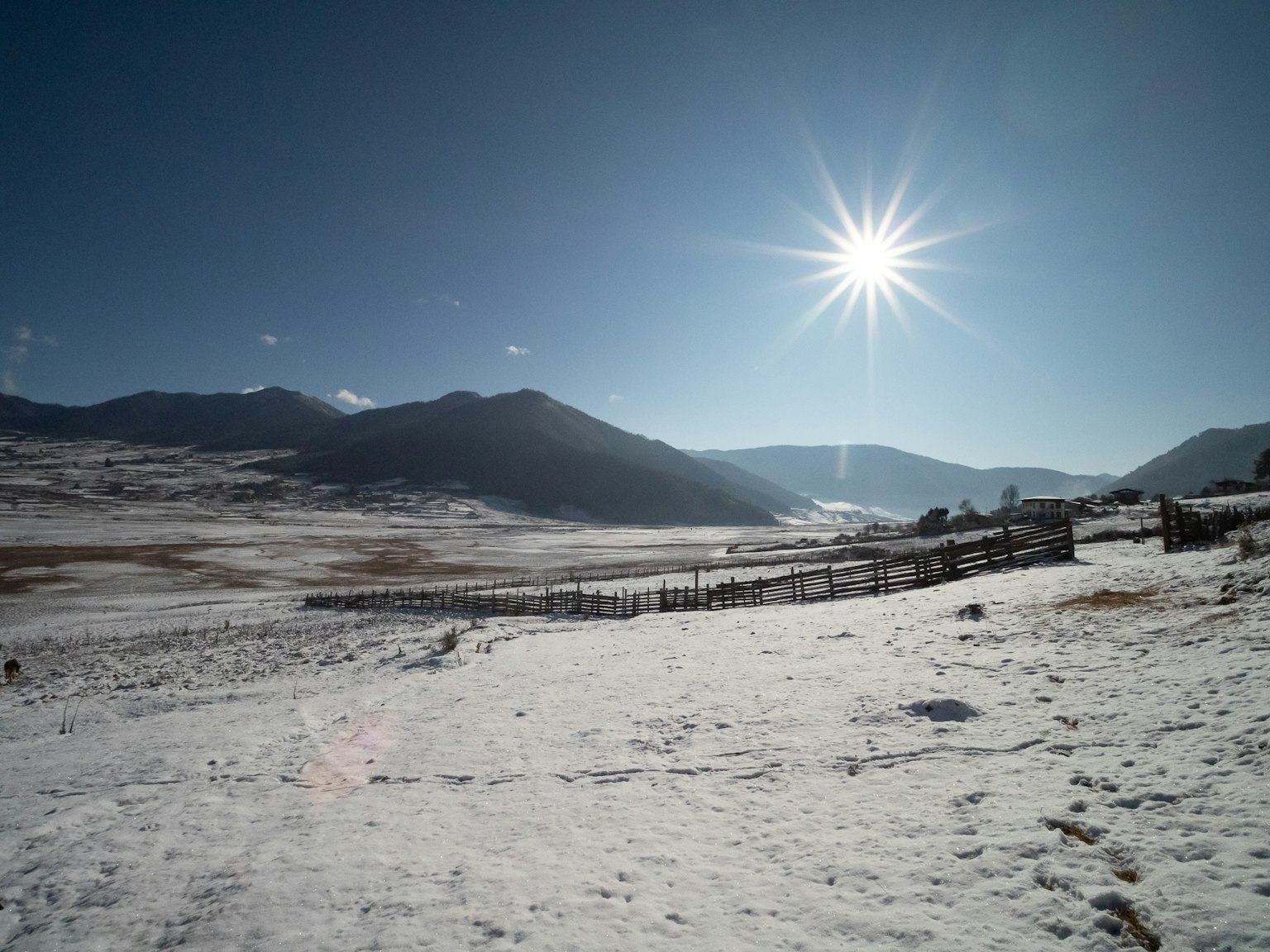 Vast snowy landscape with shining sun and distant mountains