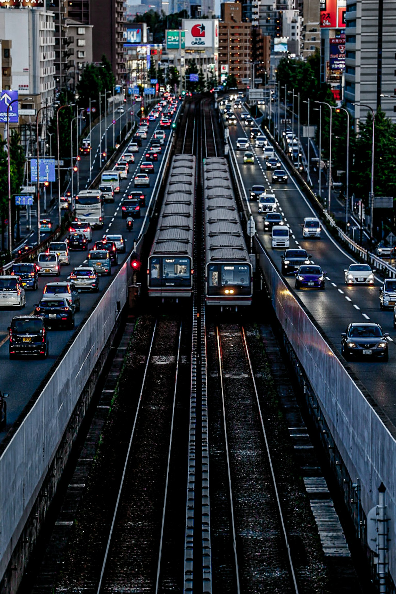 การตัดกันของรถไฟในเมืองตอนกลางคืนพร้อมการจราจร