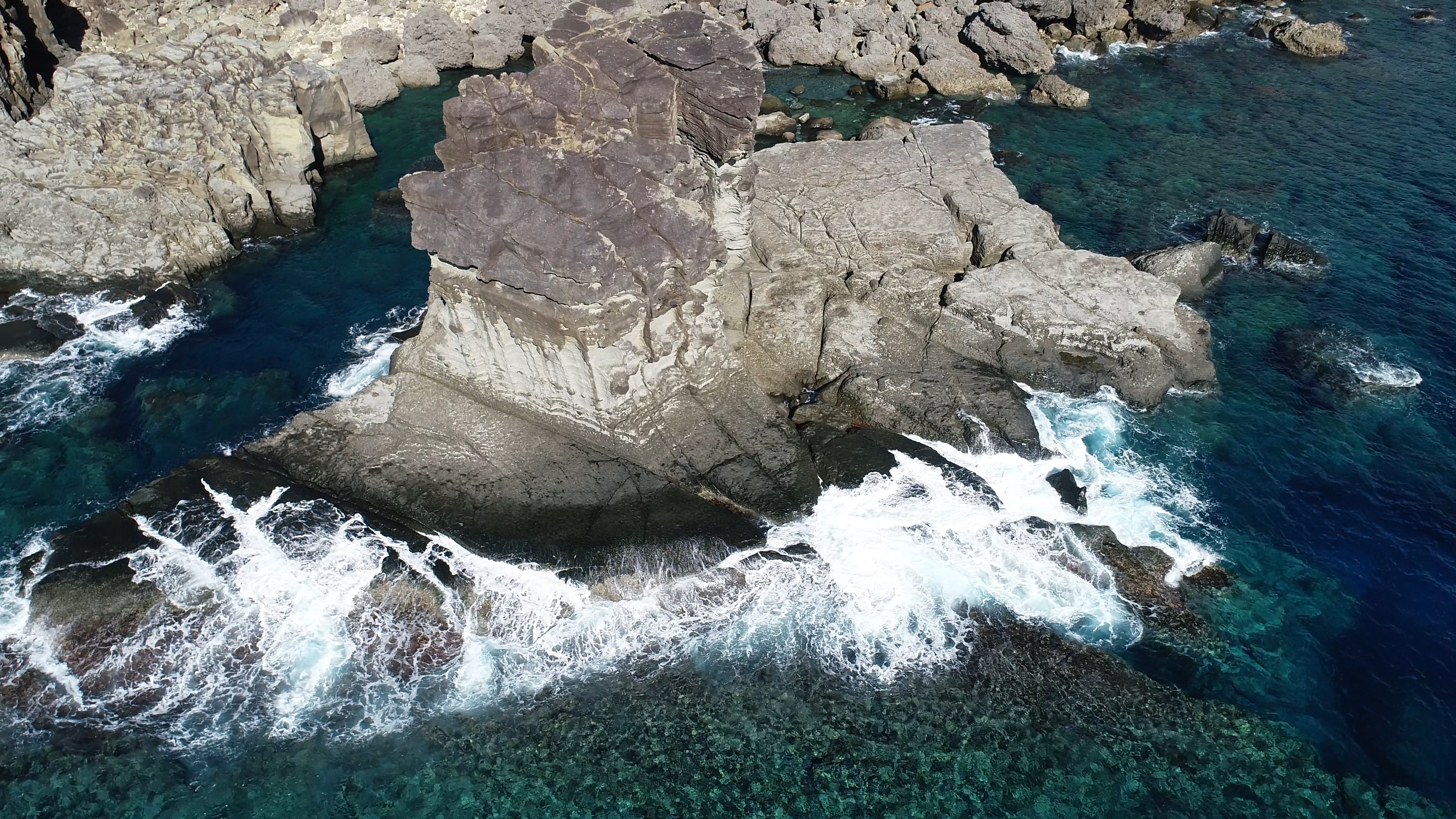 岩礁に砕ける波のある海岸の景色