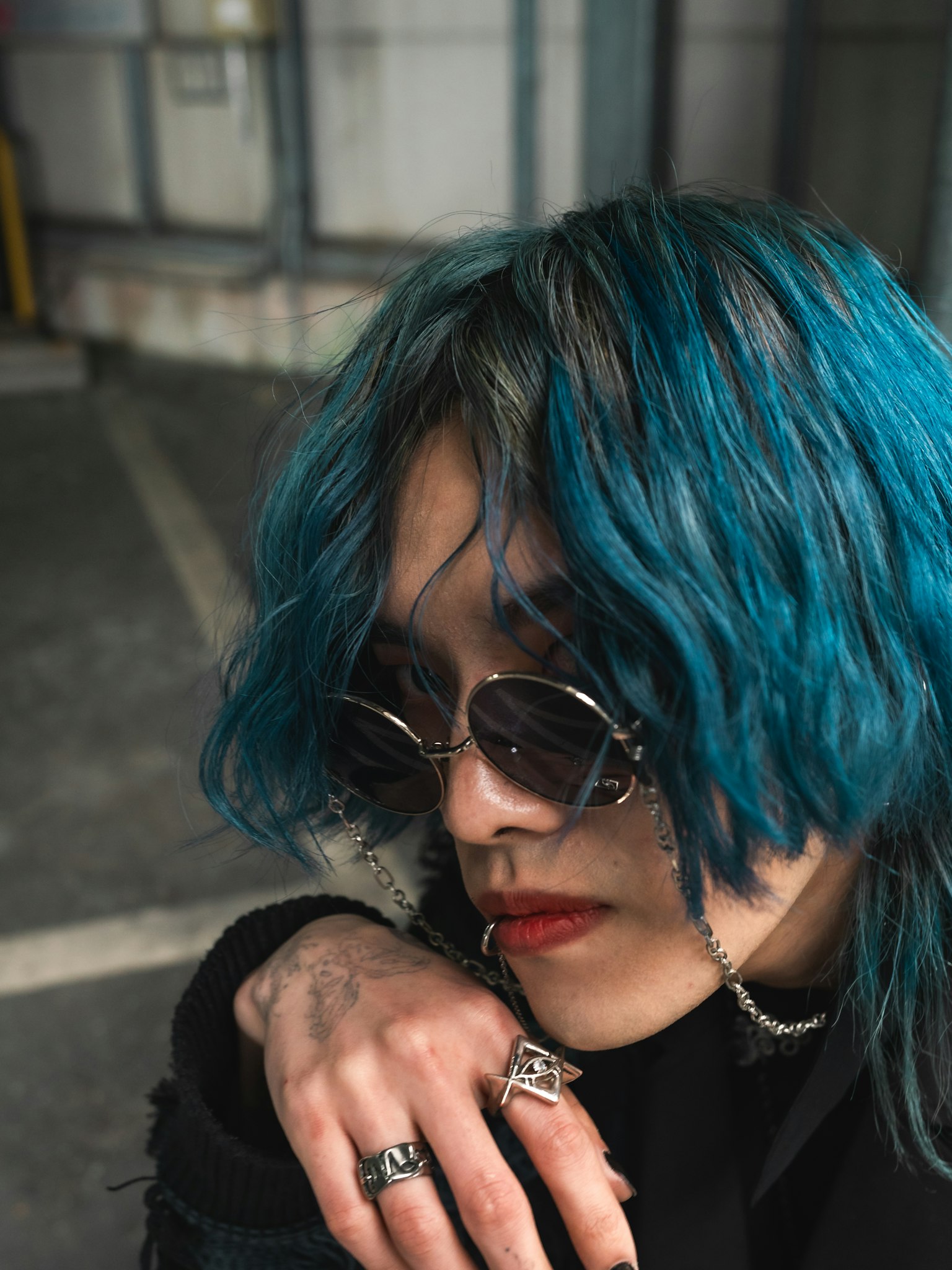 Young person with blue hair wearing sunglasses portrait