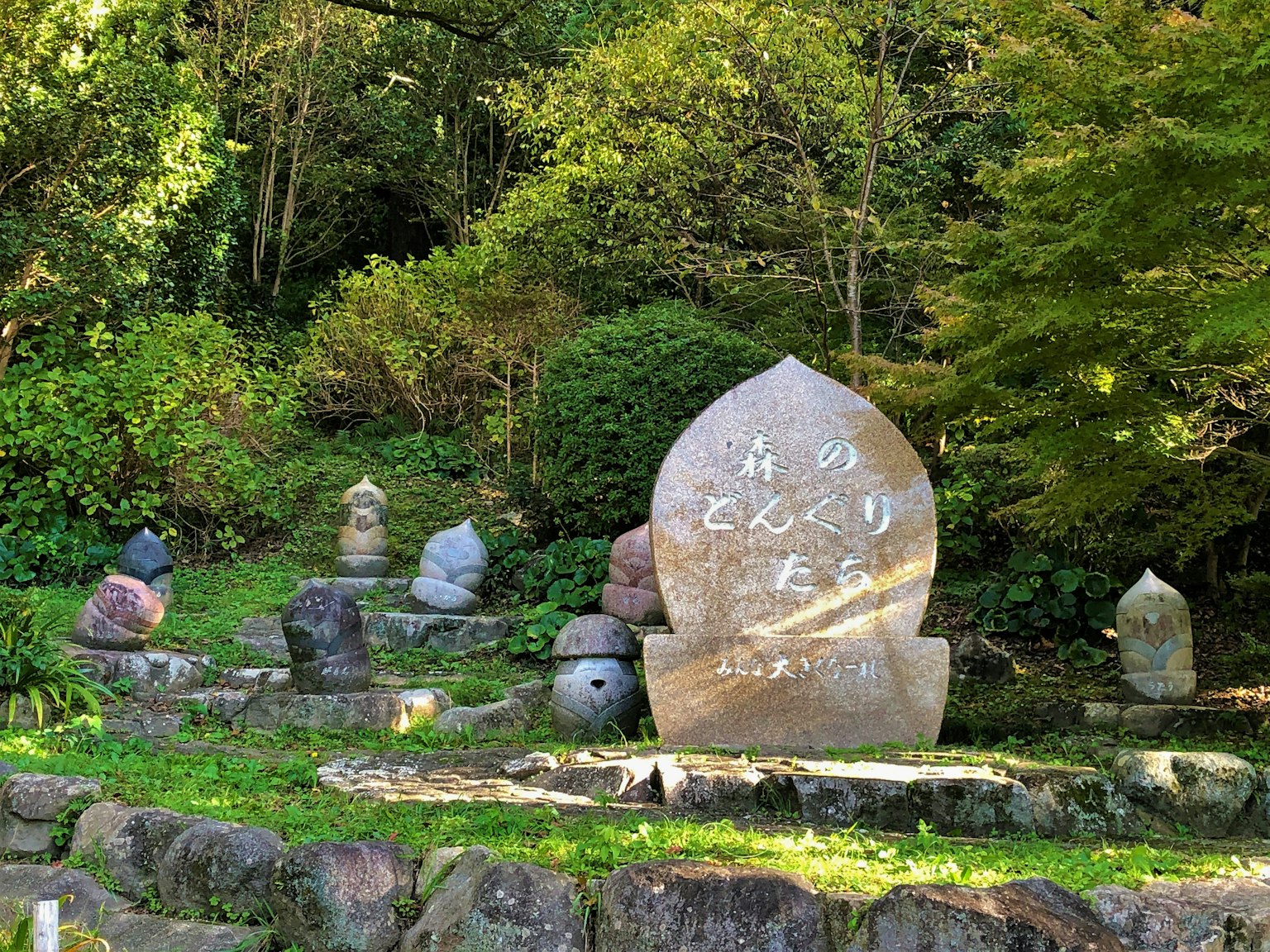 Esculturas de piedra en un parque rodeado de vegetación