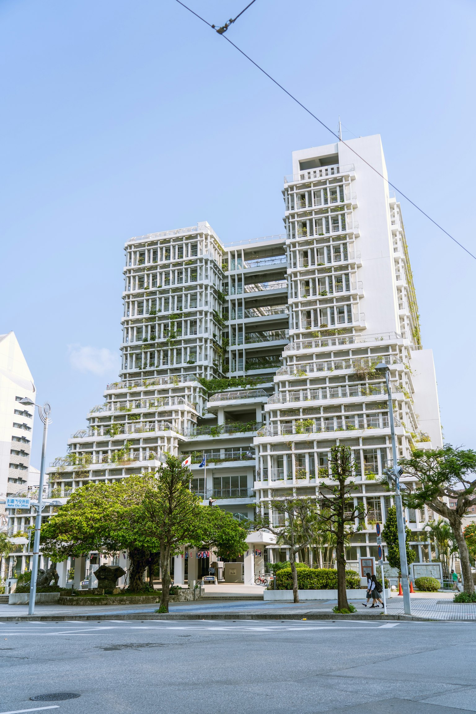 Modern building exterior featuring a multi-level design with green landscaping