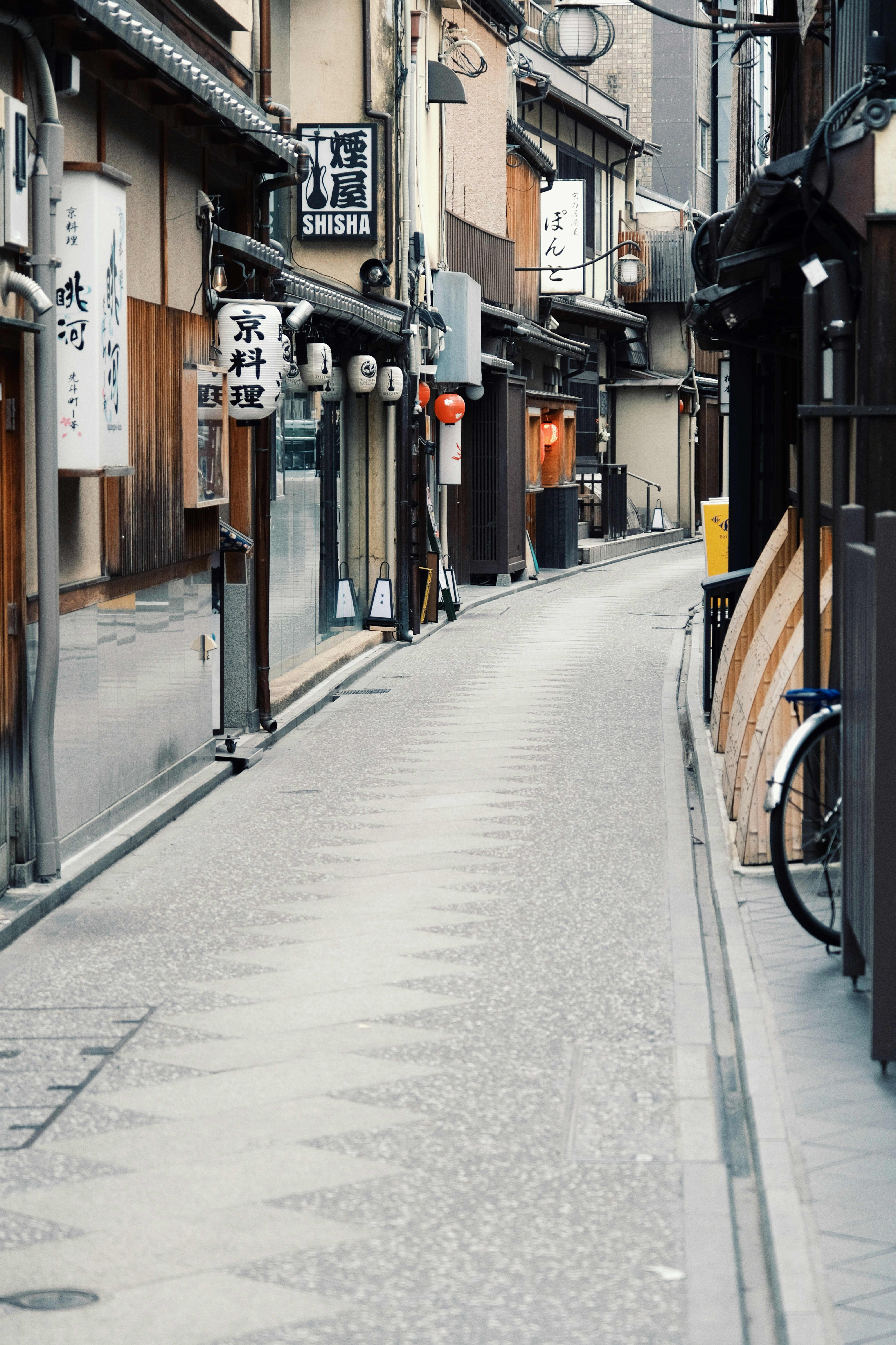 bicycles along a narrow shopping alley storefronts
