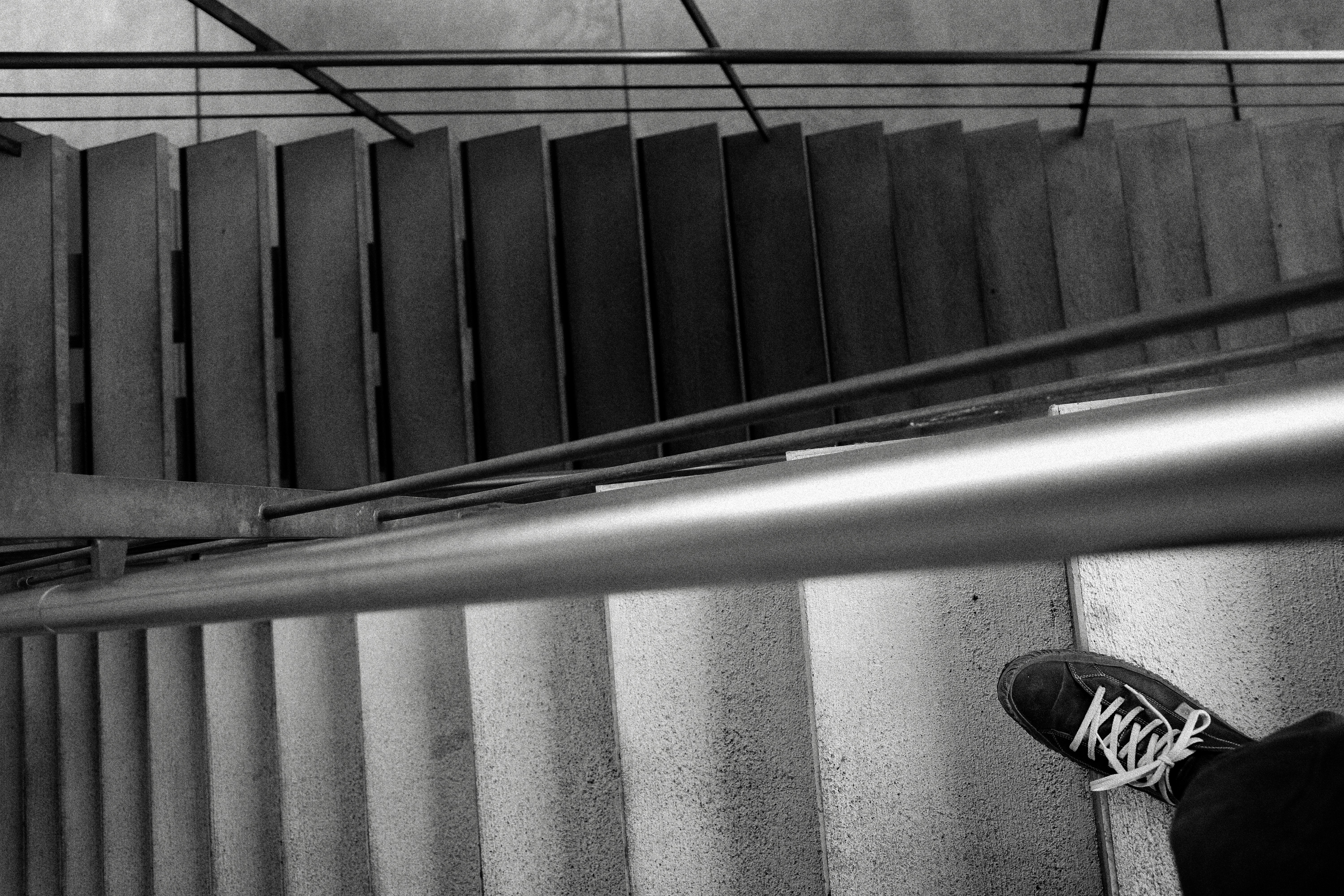 Side view of a staircase with a concrete wall and metal railing