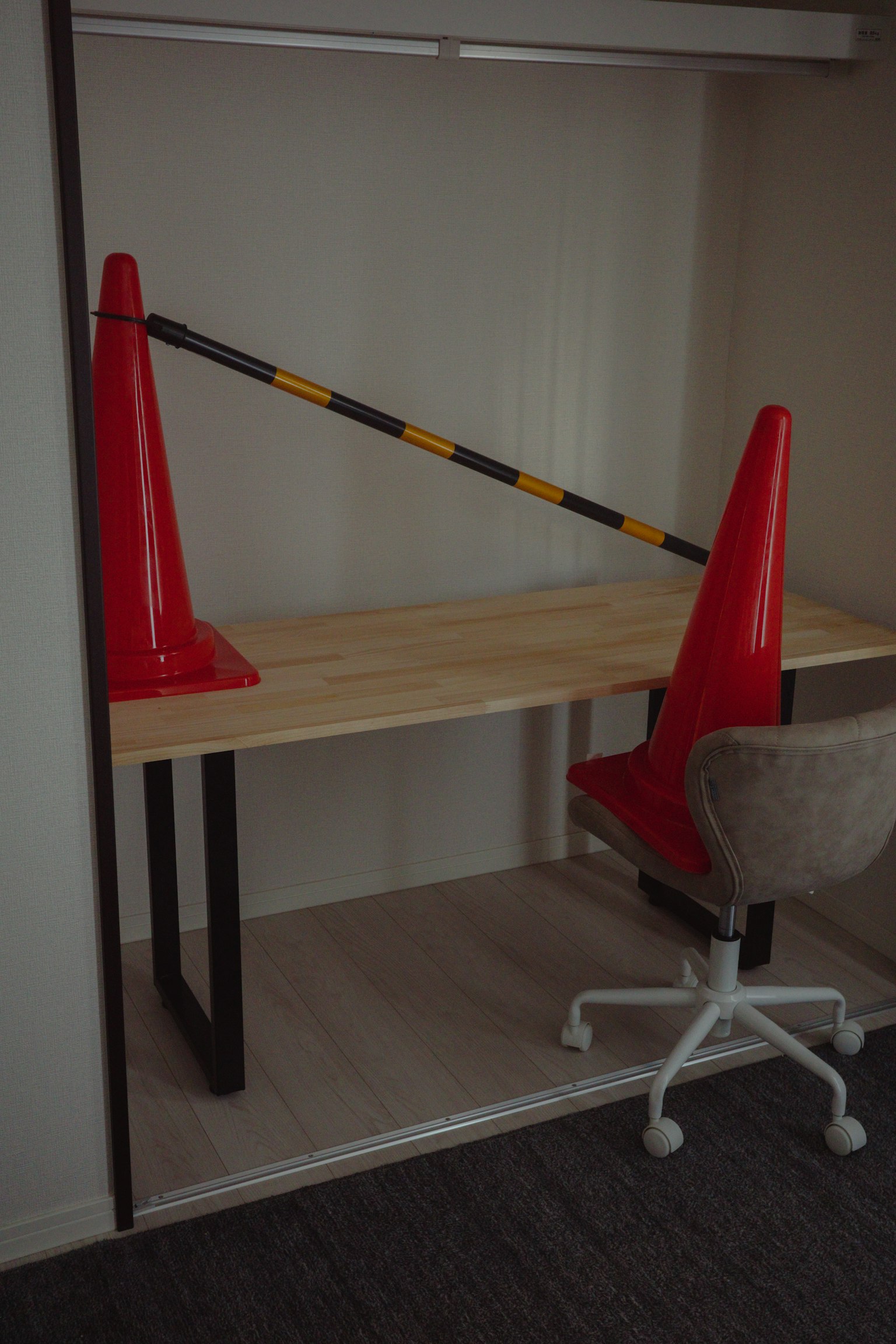 Imagen de un espacio de oficina con conos rojos y una mesa de madera