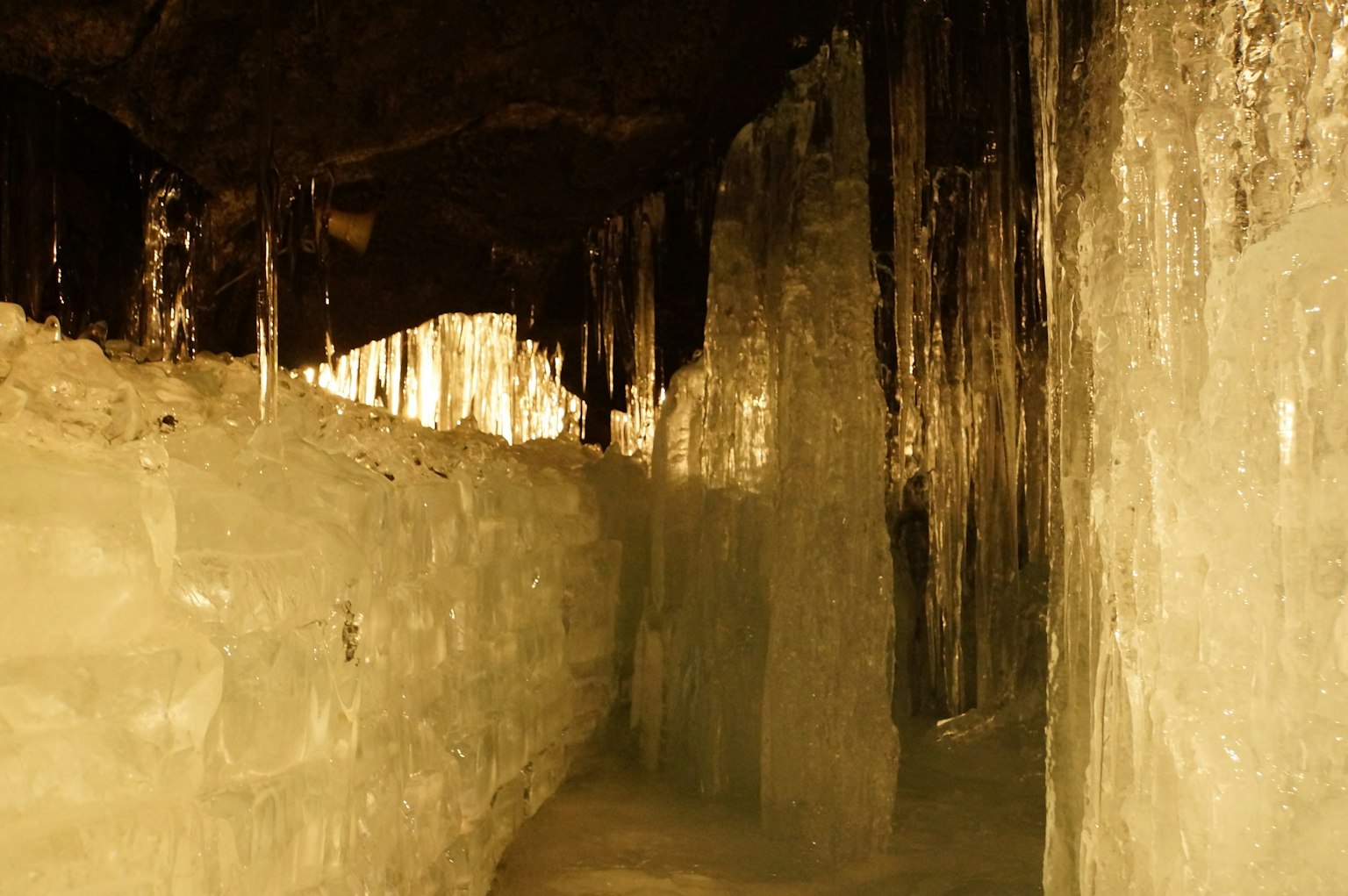 Vista interna di una grotta di ghiaccio con colonne di ghiaccio e illuminazione gialla