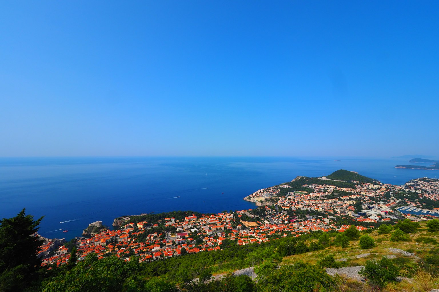 Scenic view of a coastal town under a clear blue sky