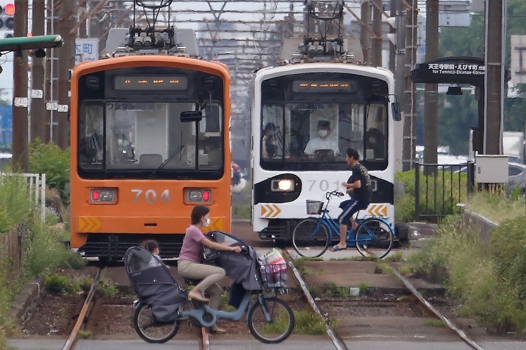 tram and bicycles along railway tracks in daylight