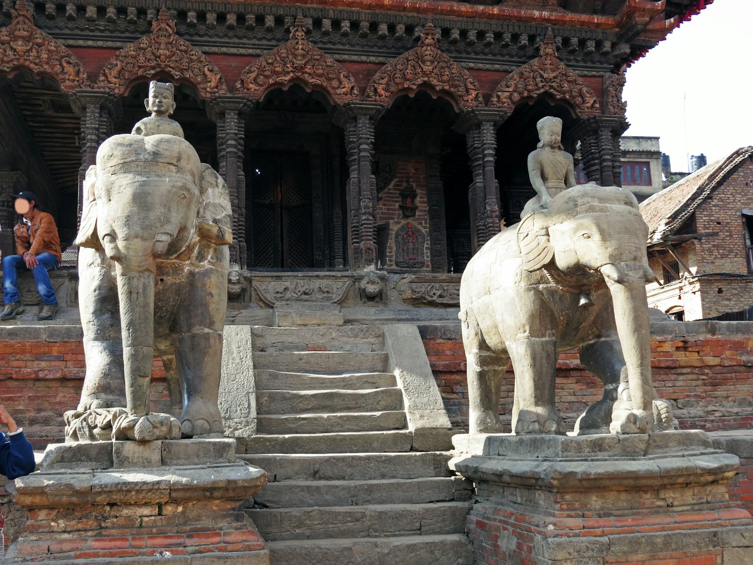 Deux éléphants en pierre de chaque côté d'un escalier devant un ancien temple