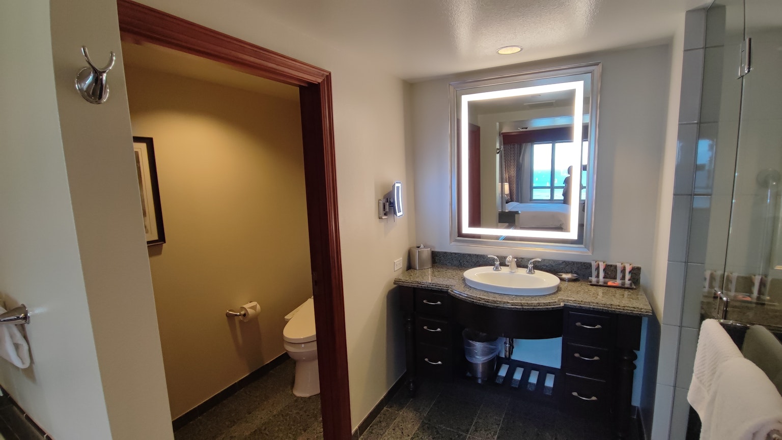 Interno di bagno luminoso con un semplice mobile lavabo e uno specchio
