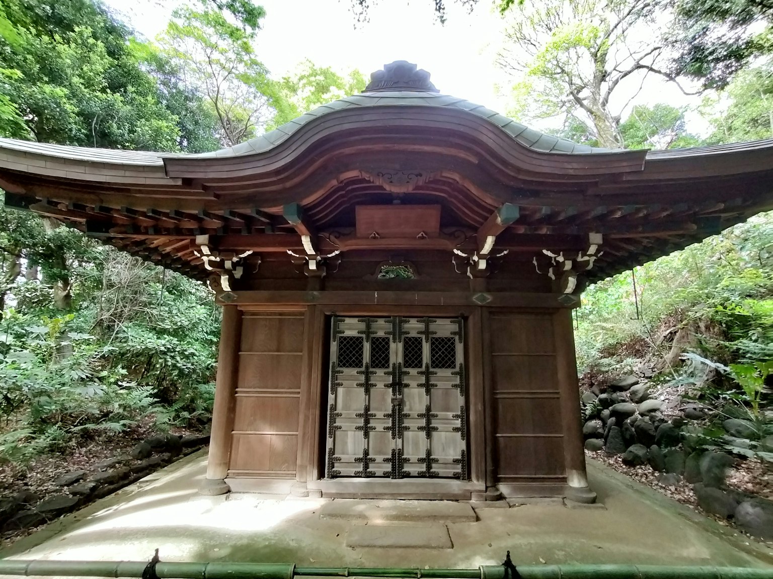 Traditional Japanese shrine building surrounded by greenery