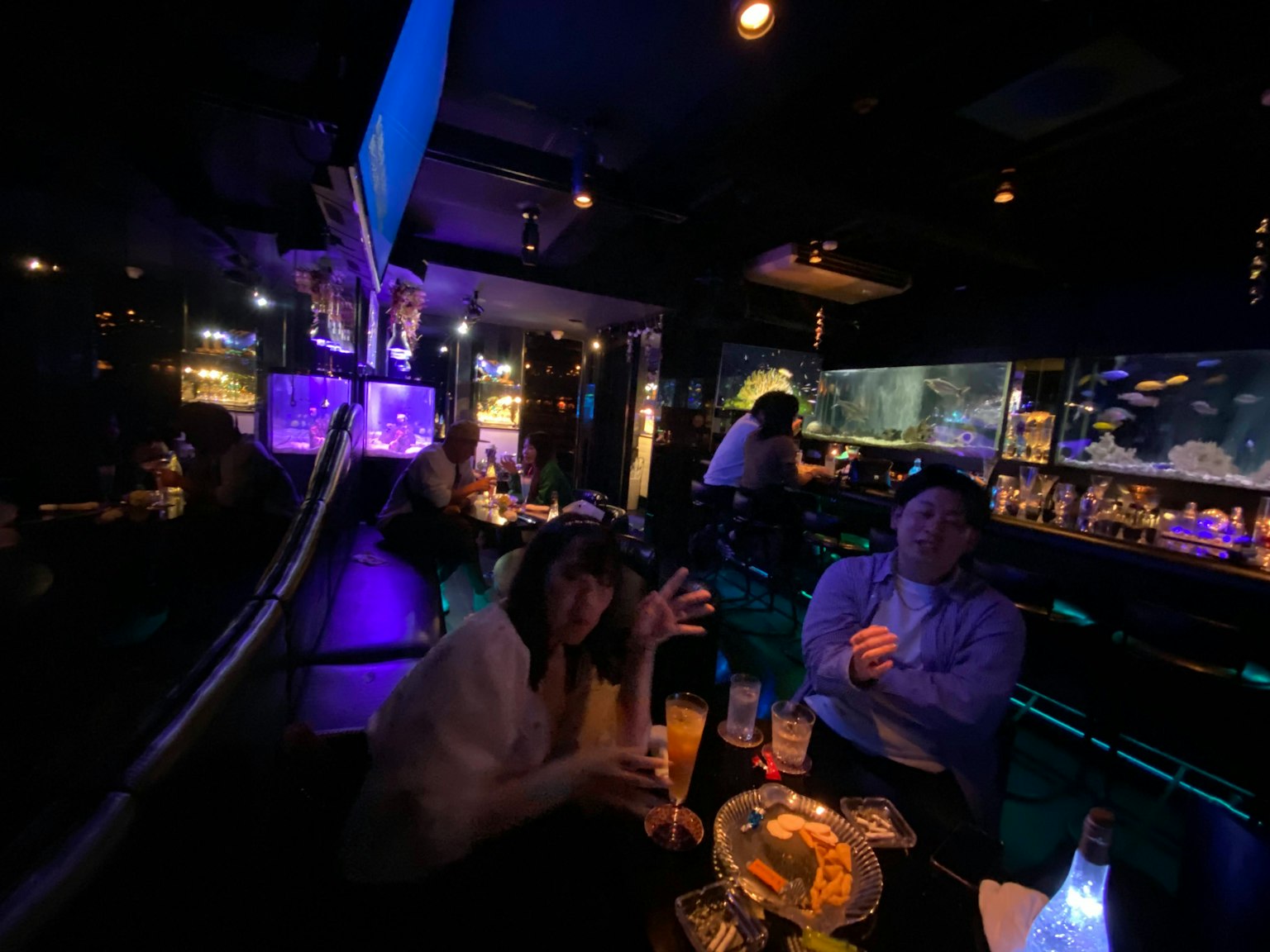 Des gens s'amusant dans un bar faiblement éclairé avec un éclairage coloré